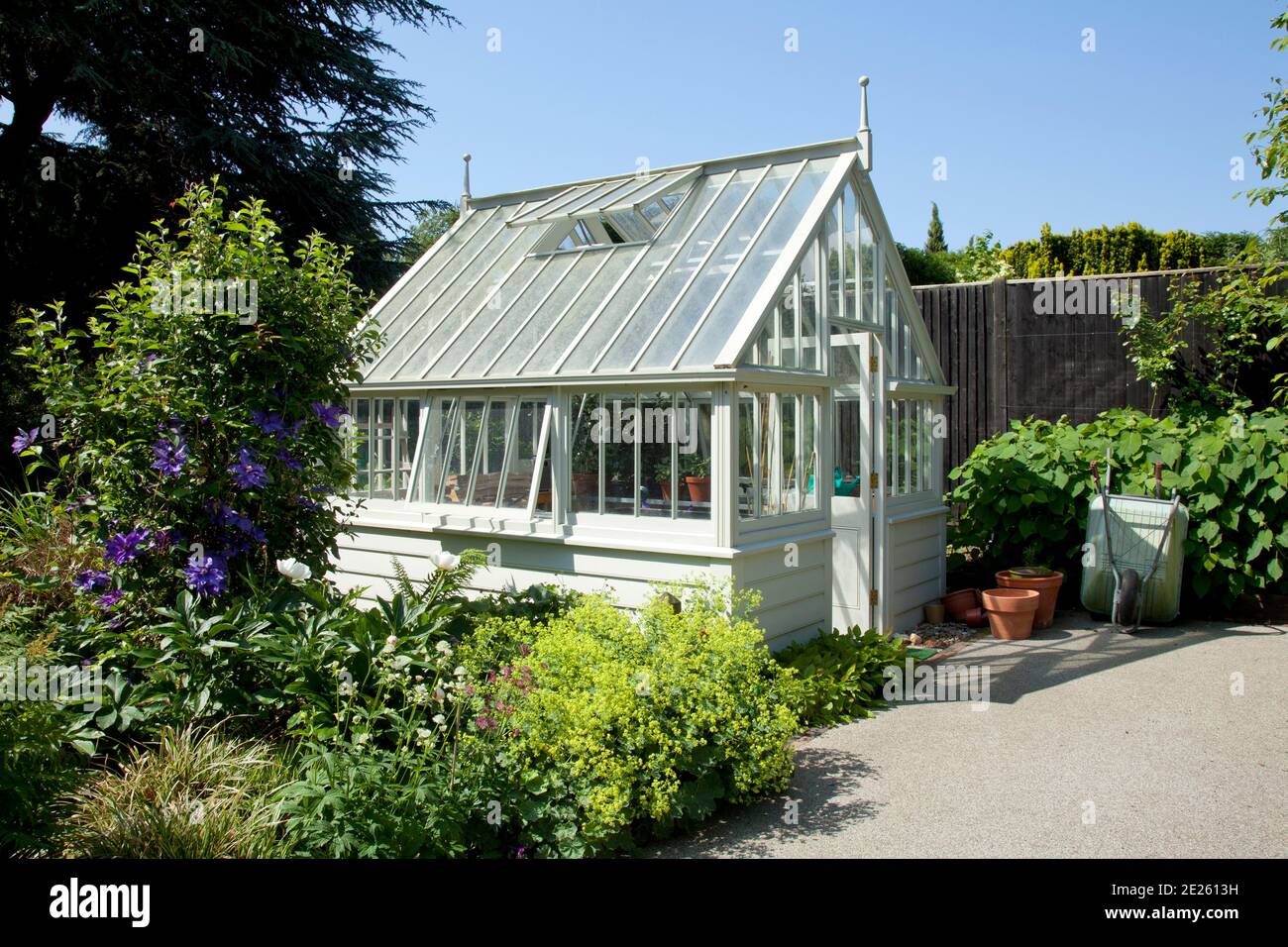 White greenhouse in landscaped garden Stock Photo