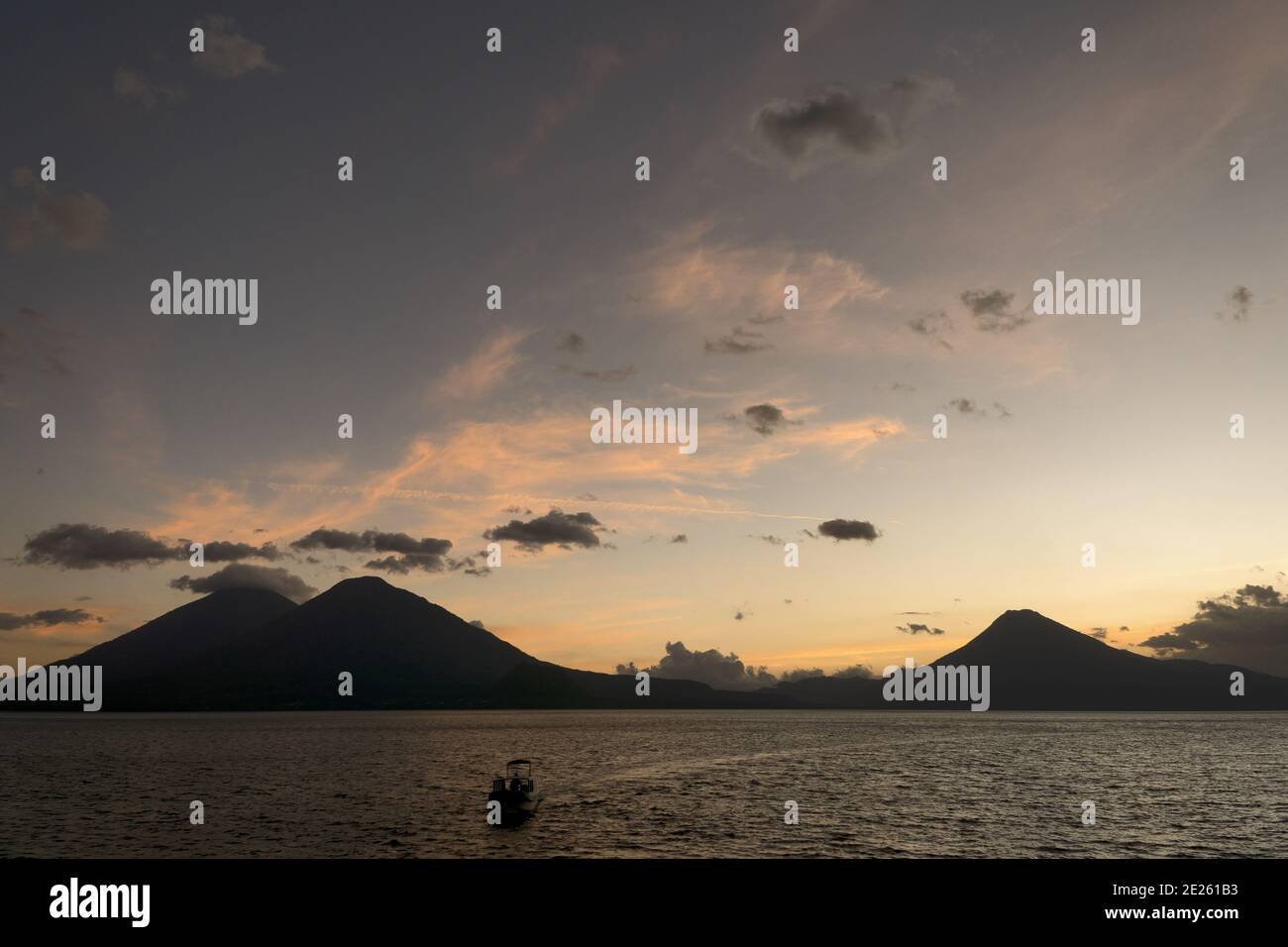 Guatemala, Central America: sunset with boats at lake Atitlán (Atitlan) with volcanos Atitlan, Toliman, SanPedro Stock Photo
