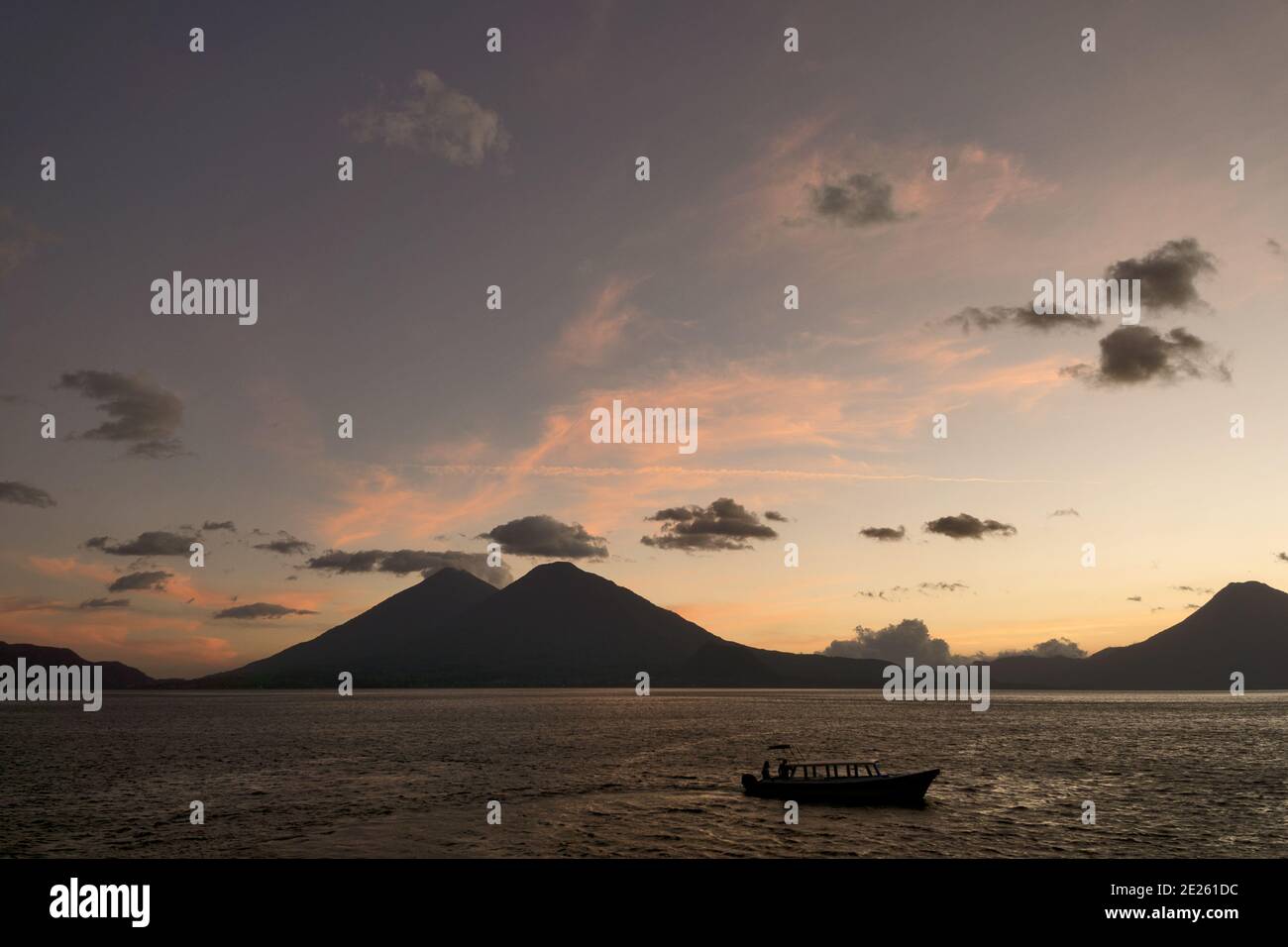 Guatemala, Central America: sunset with boats at lake Atitlán (Atitlan) with volcanos Atitlan, Toliman, SanPedro Stock Photo
