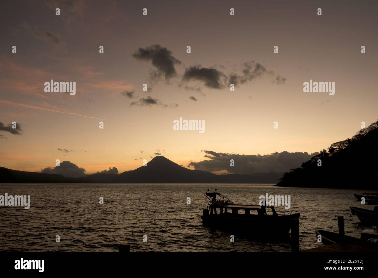 Guatemala, Central America: sunset with boats at lake Atitlán (Atitlan) with volcanos Atitlan, Toliman, SanPedro Stock Photo