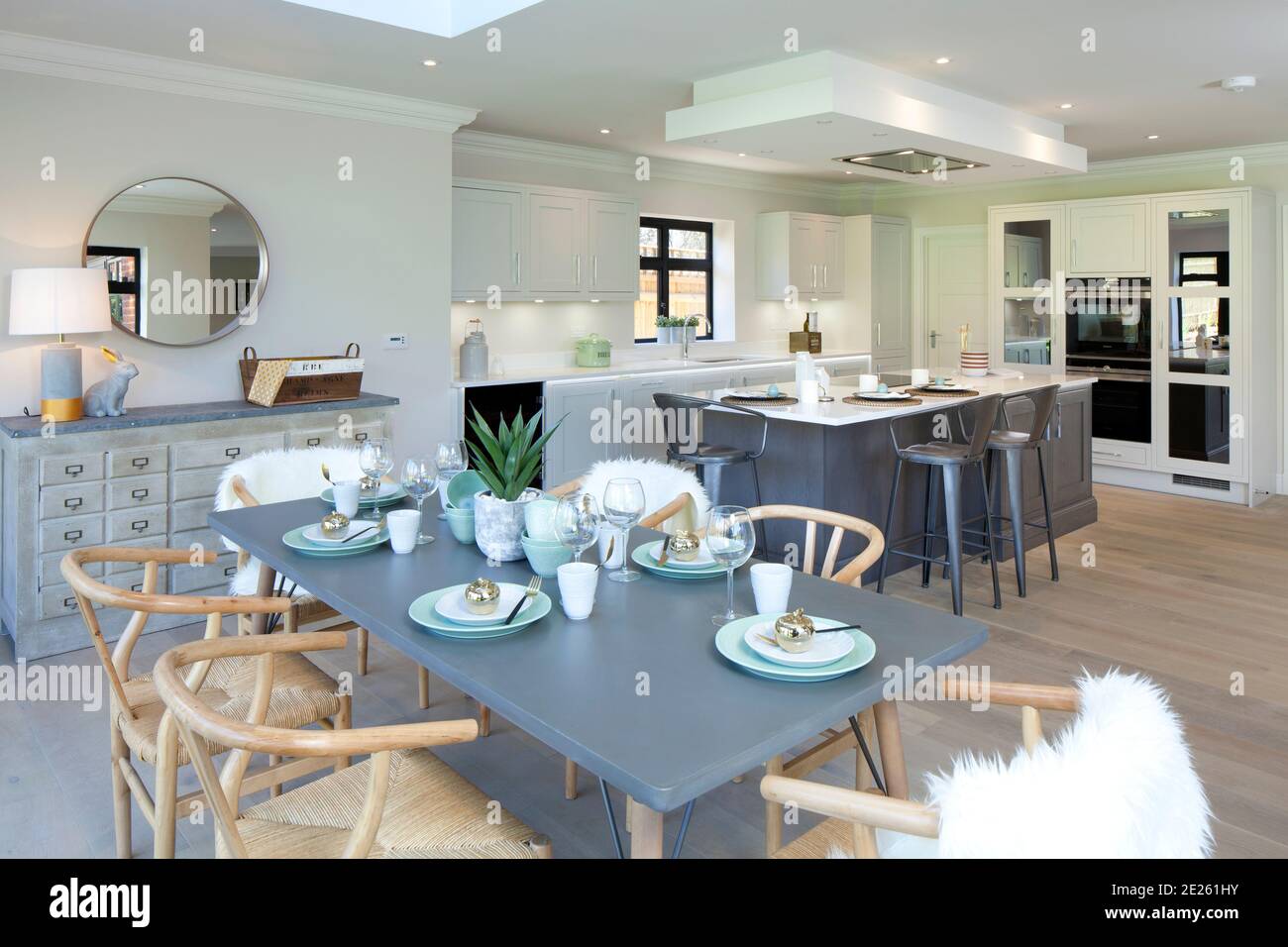 Show home contemporary grey kitchen with dressed laid up table Stock Photo
