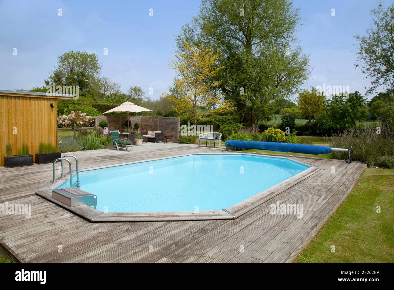 Octagonal private swimming pool with wooden decking surround Stock Photo