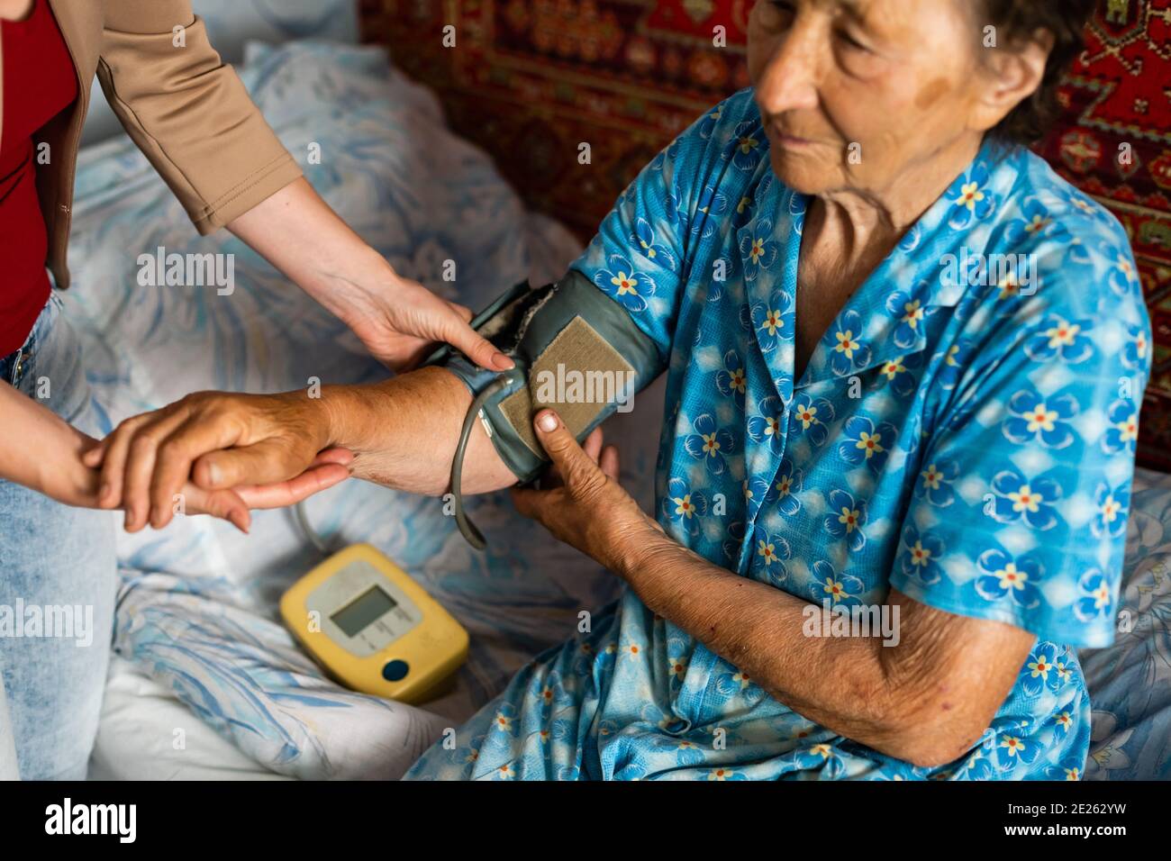 Female doctor measuring blood pressure of senior woman Stock Photo - Alamy