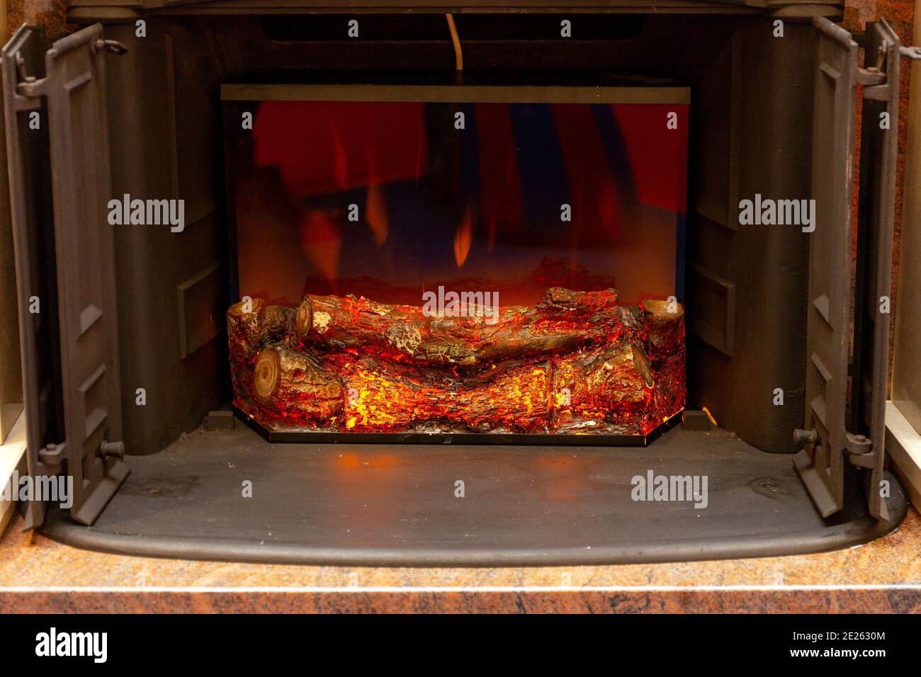 Flickering Effects Ceramic Wood Logs in Electronic Firebox Stock Photo