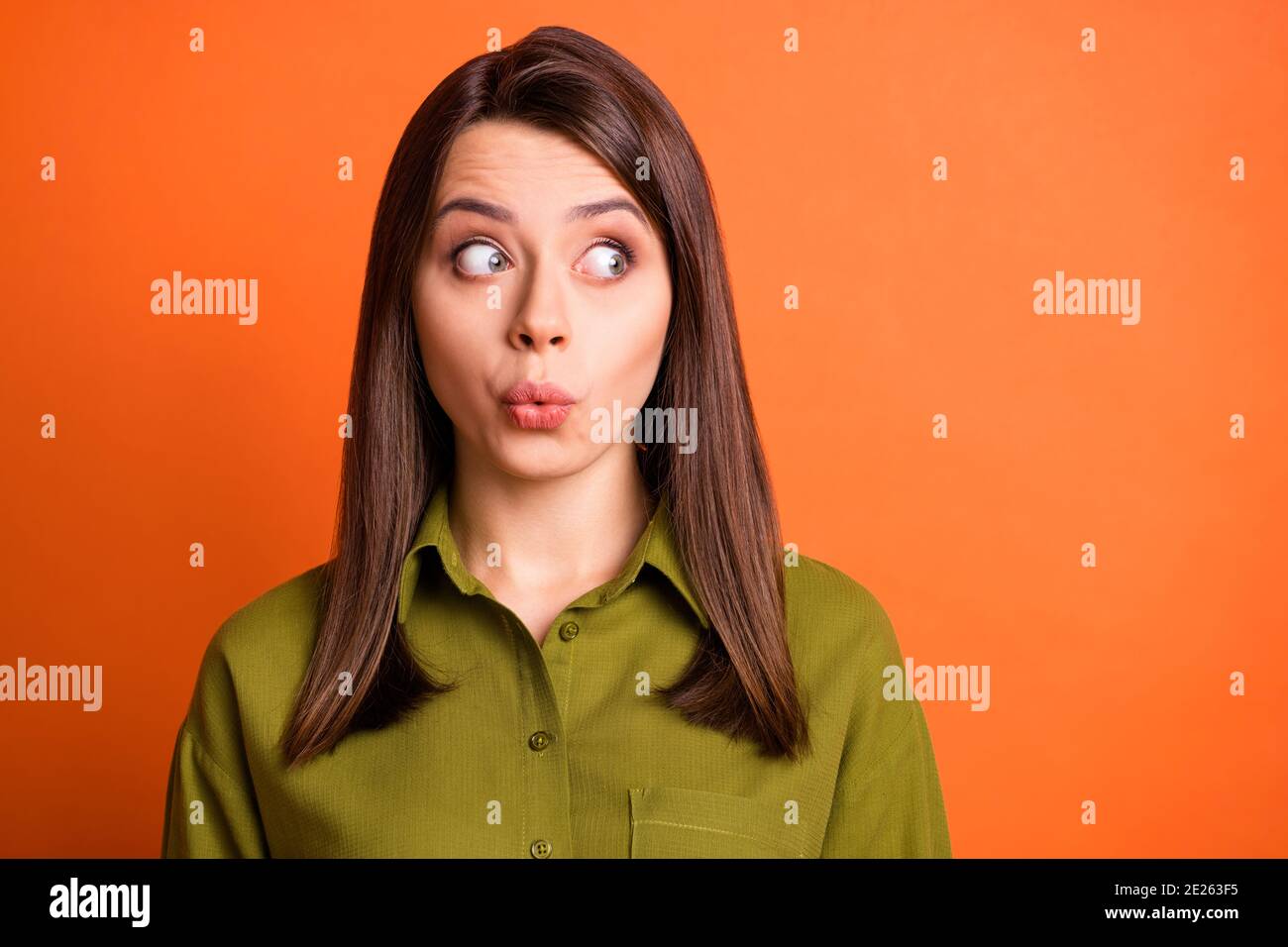 Photo of lovely girl look side empty space funny lips close wear green shirt isolated orange color background Stock Photo