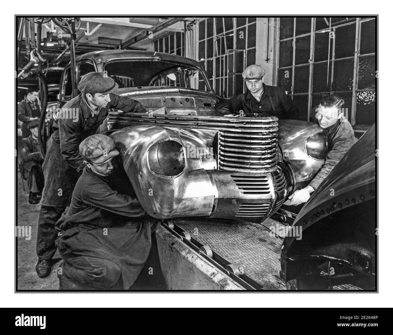 GERMAN CAR ASSEMBLY 1938 Opel Capitan motorcar steel body being assembled in the Opel Car Plant assembly factory production line Germany Opel Kapitän sedan.The Kapitän was the last new Opel model to appear before the outbreak of the Second World War, developed during 1938 and launched in the spring of 1939 at the Geneva motor show. Production began in November 1938 Stock Photo