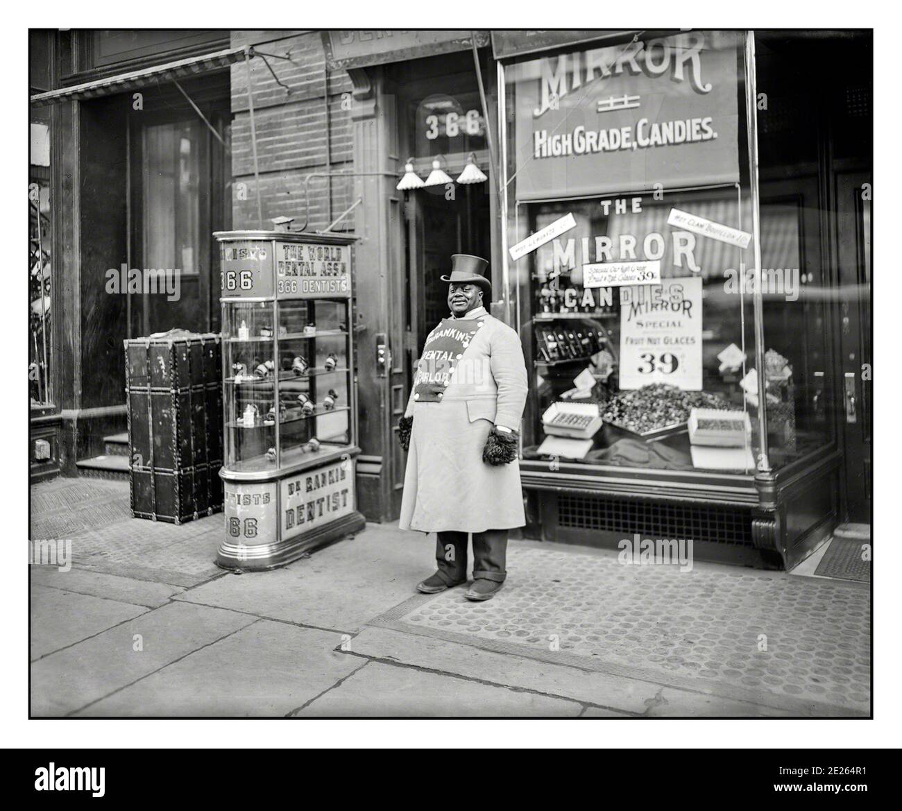 FIFTH AVENUE 1900’s New York archive street scene on Fifth Avenue Manhattan, New York City.” A brand ambassador stands advertising for Dr. Rankin’s Dental Practice Parlor, conveniently close to a confectionary sweet candy store 1905 Stock Photo