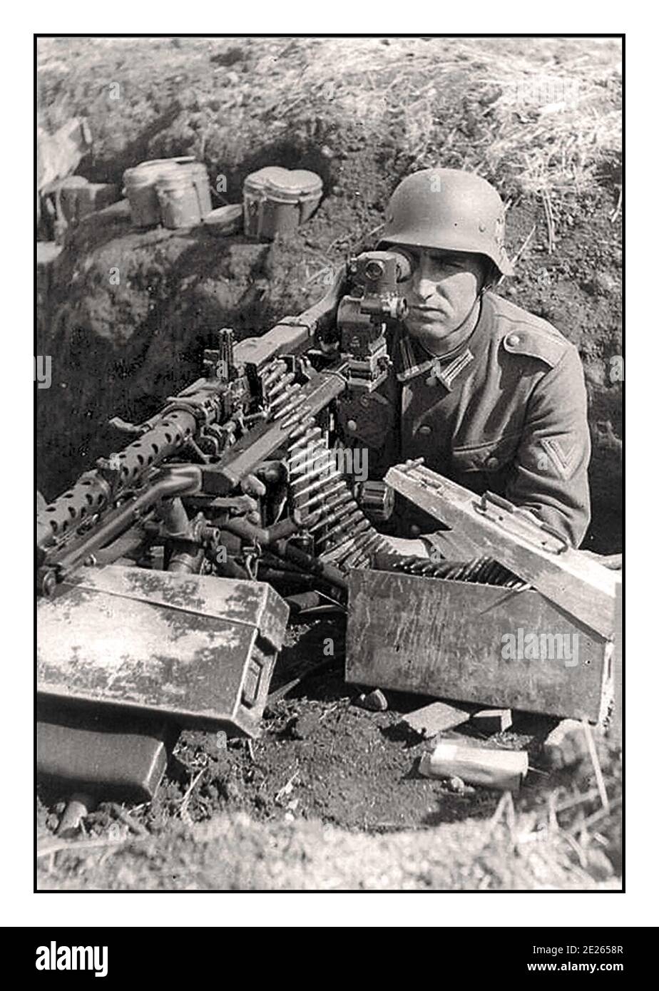 WW2 Propaganda Image Wehrmacht Army Nazi soldier in trench dugout  with MG-42 Machine Gun with optical sight, ammunition boxes close to hand Stock Photo