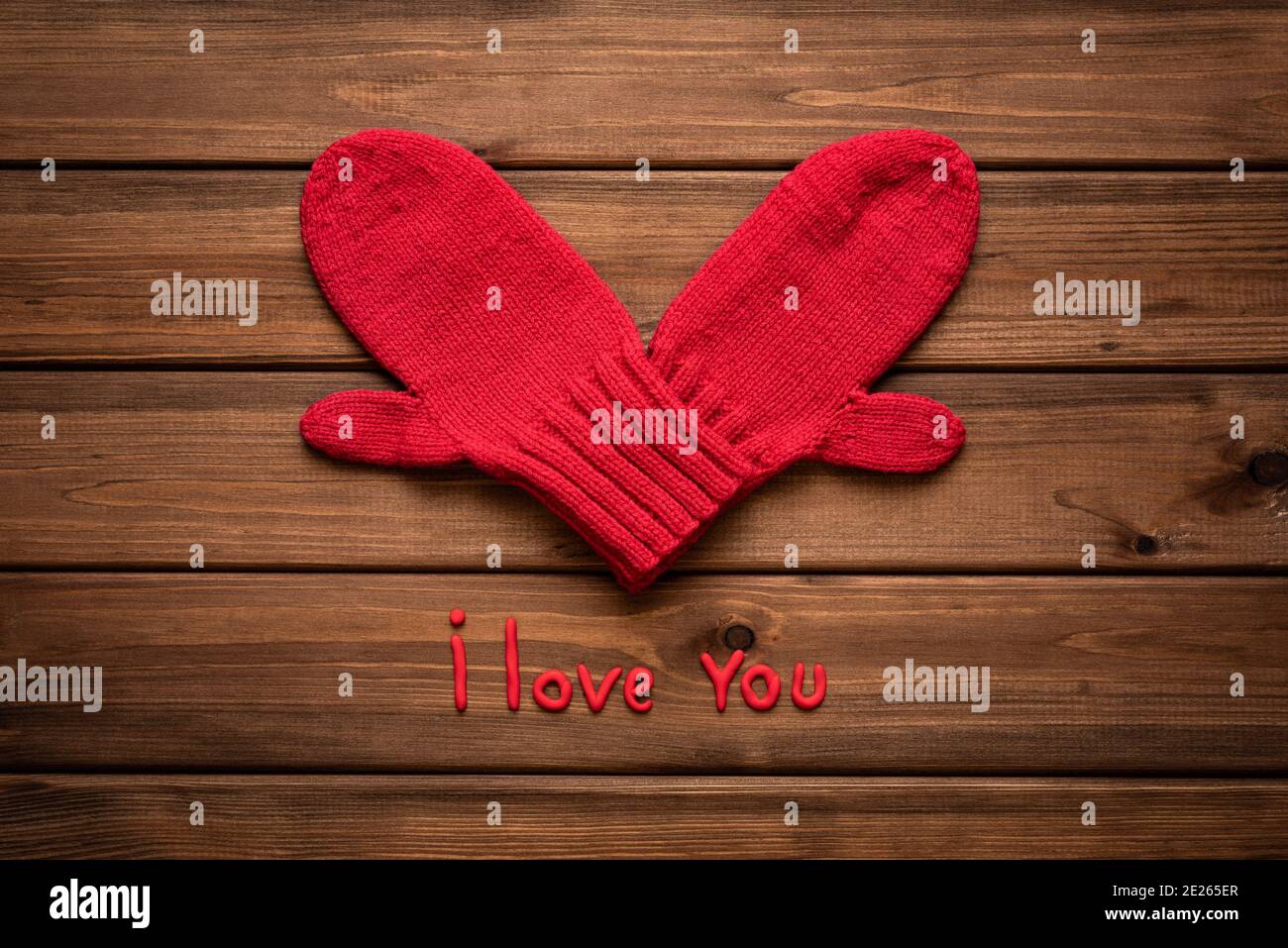 Valentines day card with heart made of red mittens on wooden vintage  background and phrase about love Stock Photo - Alamy