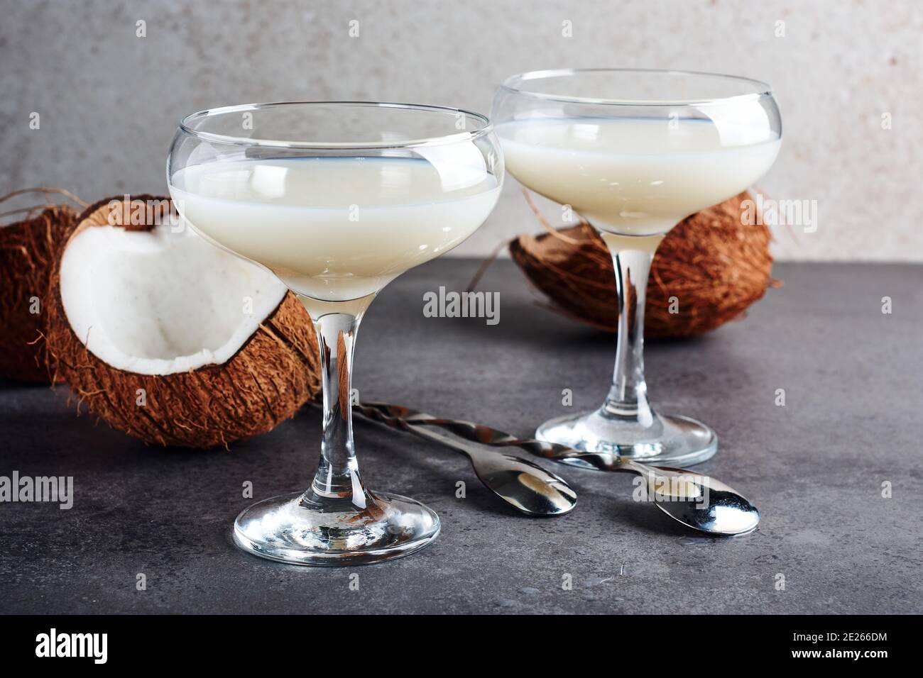 Pina Colada cocktail in a glass and coconut halves. Stock Photo