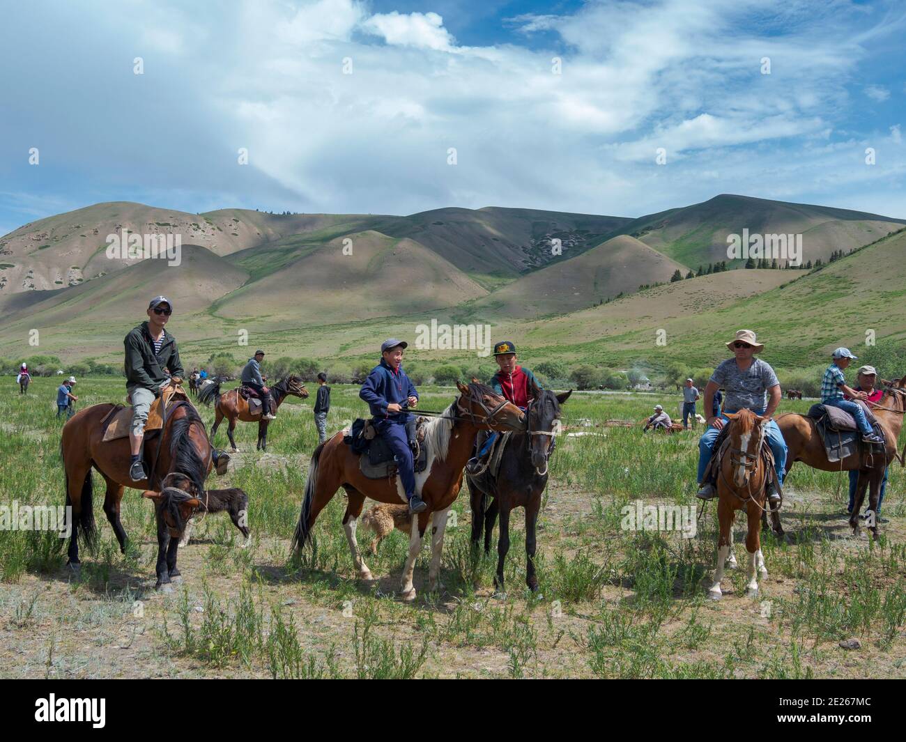 Spectators arriving by horse.  Folk Festival commemorating the origin myth the Tien Shan Maral (Tian Shan wapiti), an origin myth of the Kyrgyz tribes Stock Photo
