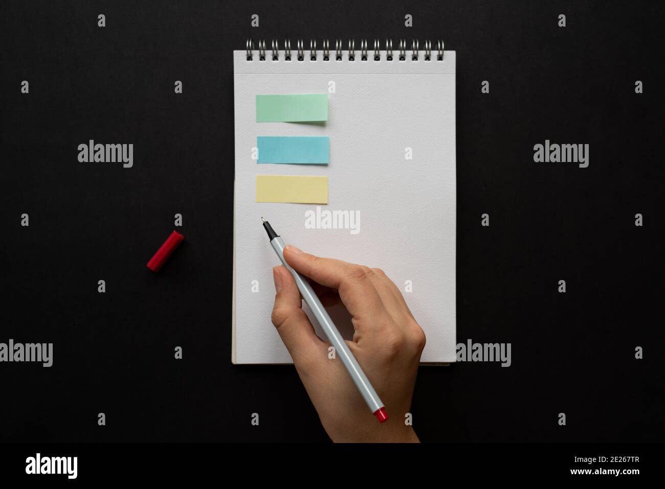 Taking notes in blank paper white notebook colorful post-it woman hand ...