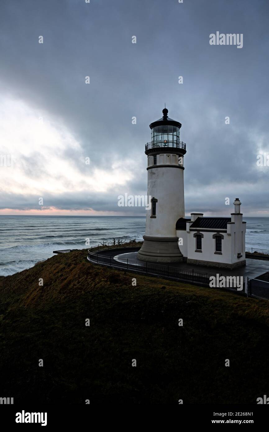 WA19107-00...WASHINGTON - Cloudy morning sunrise at North Cape Lighthouse in Cape Disappointment State Park. Stock Photo