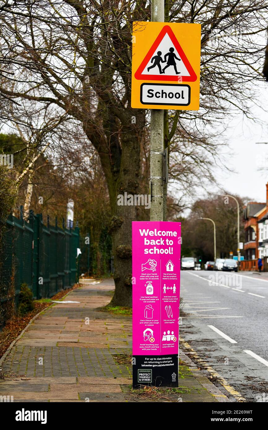 School crossing sign in Belgrave, Leicester with Covid advice. Stock Photo