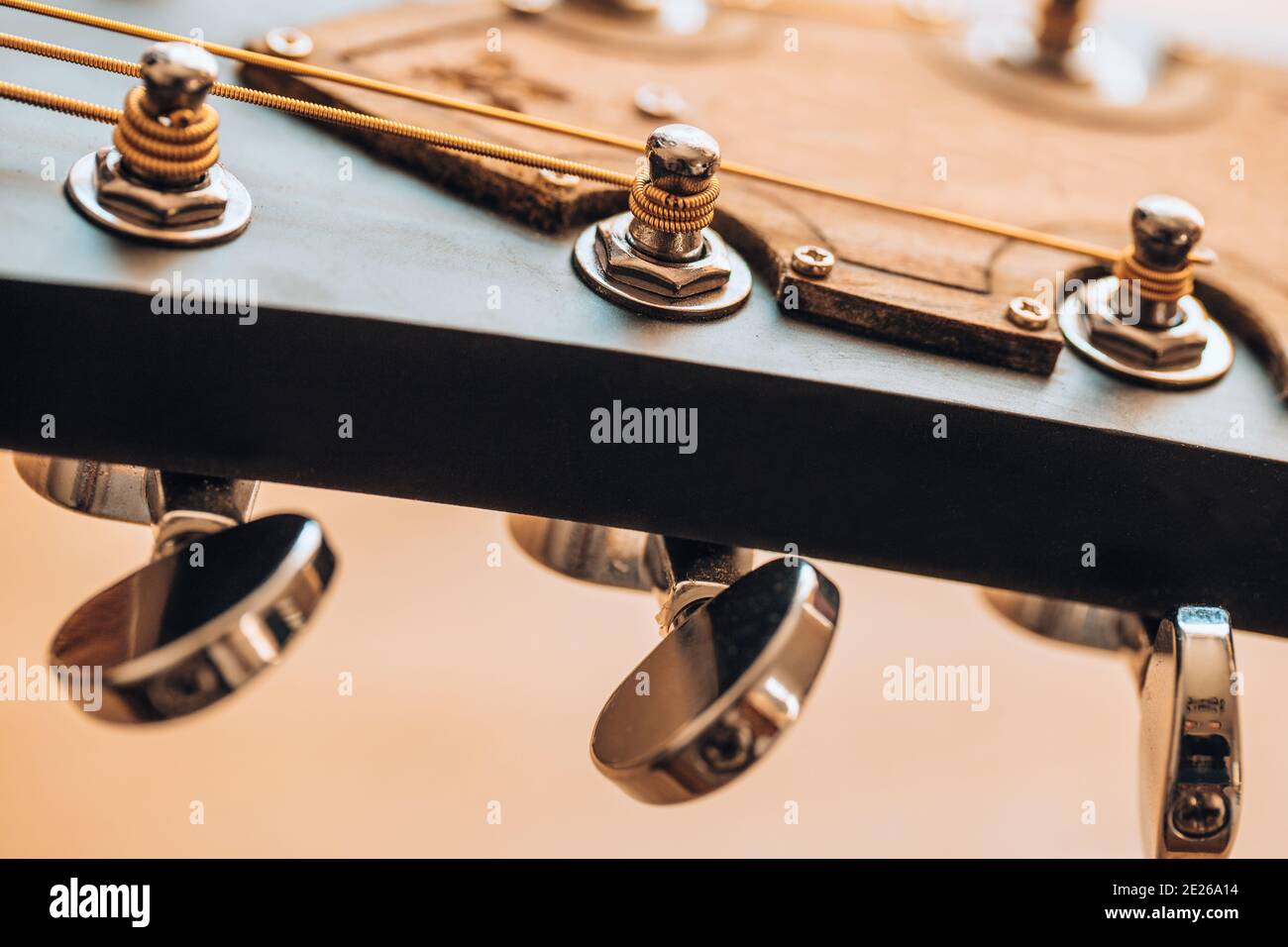 Attaching the strings to the fretboard tuning the guitar closeup of the tuning machine