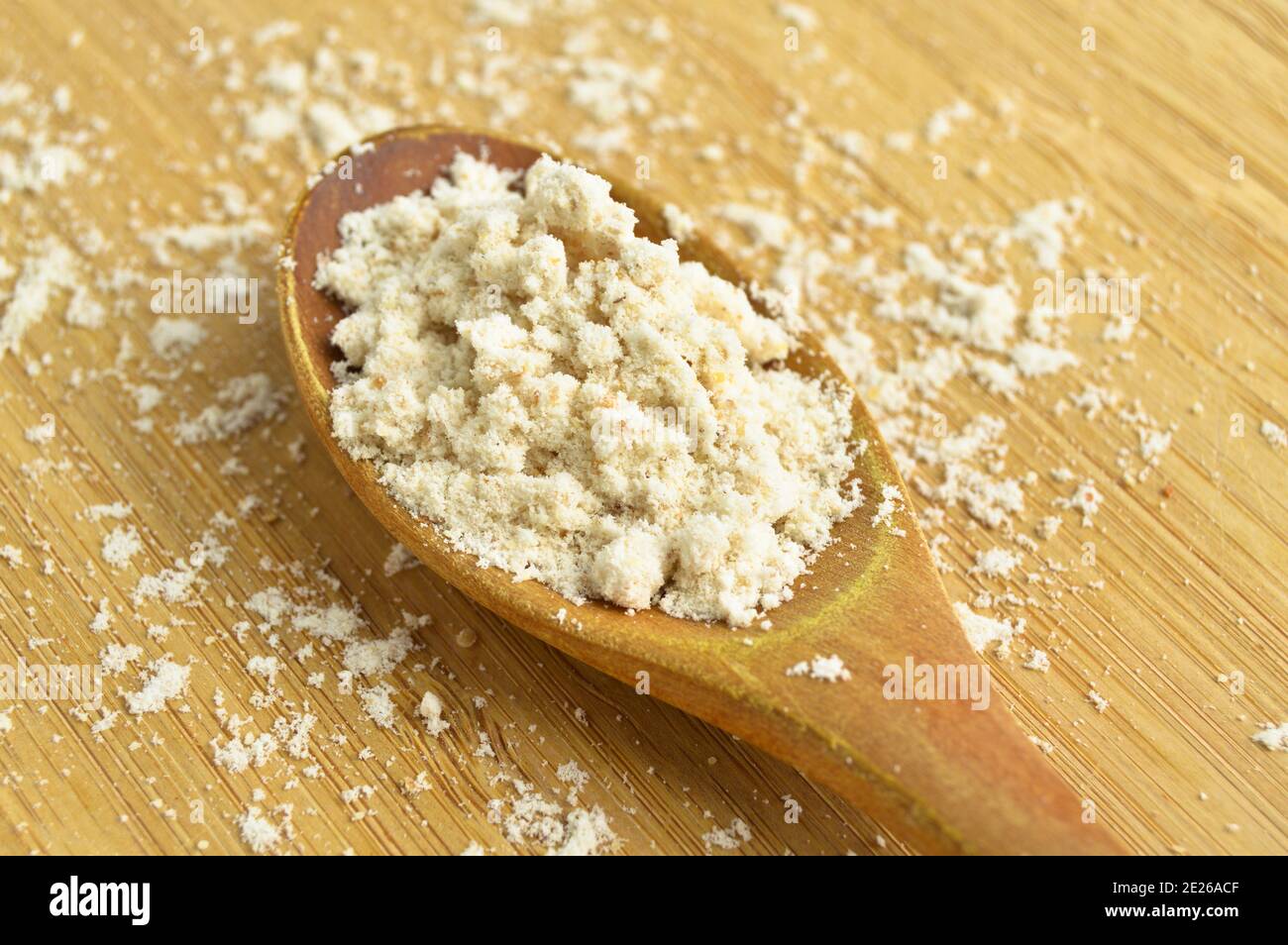 Spice type used to give flavor in powder mahleb or mahaleb pastries, in wooden spoon, on bamboo cutting board Stock Photo