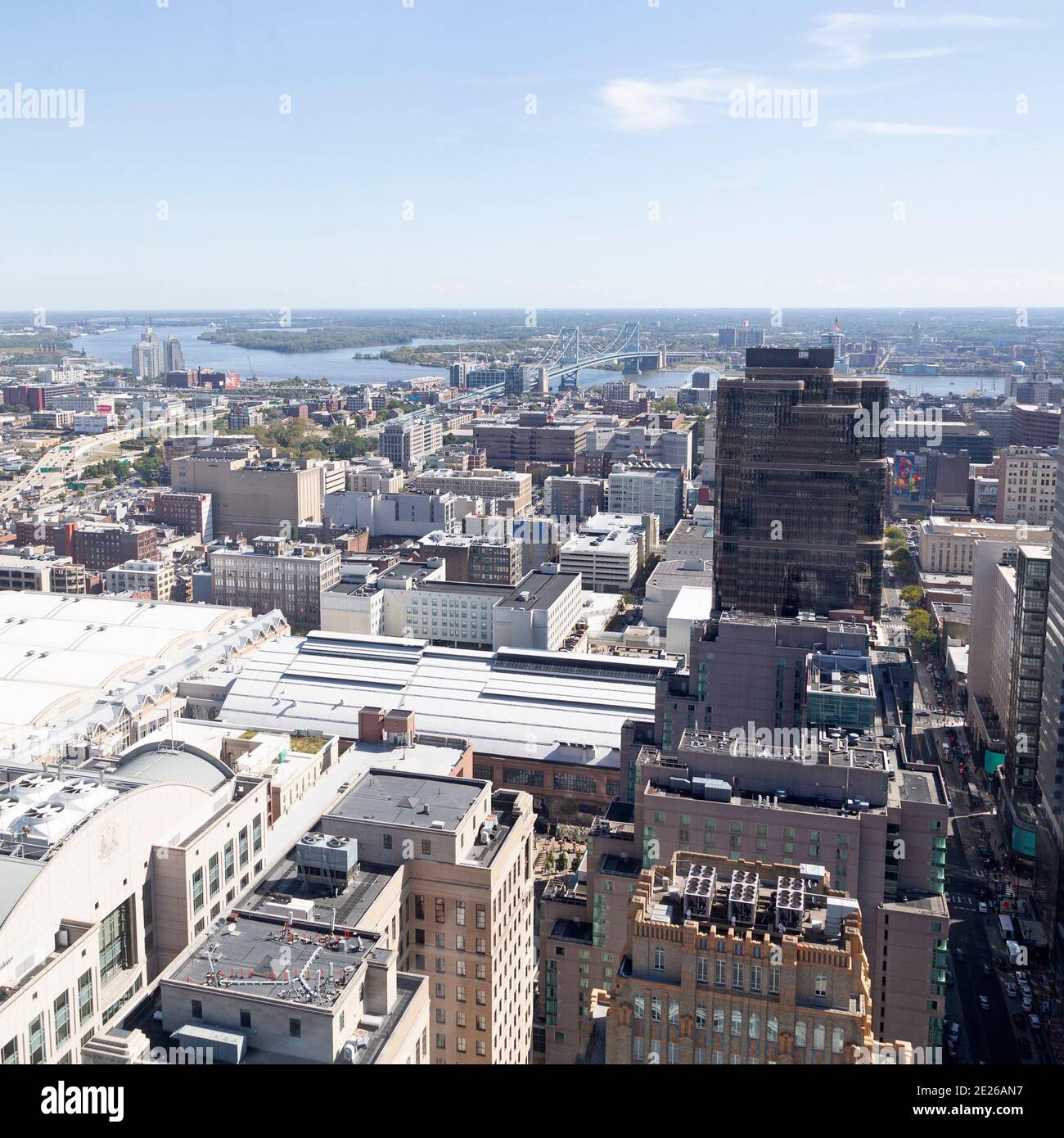 Rooftops of buildings in downtown Philadelphia, USA. The Benjamin Franklin Bridge spans the Delaware River. Stock Photo