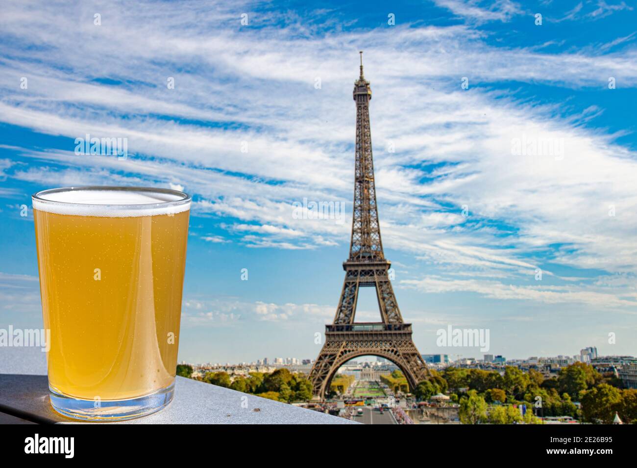 Glass of light beer against Paris skyline with Eiffel tower background. Stock Photo