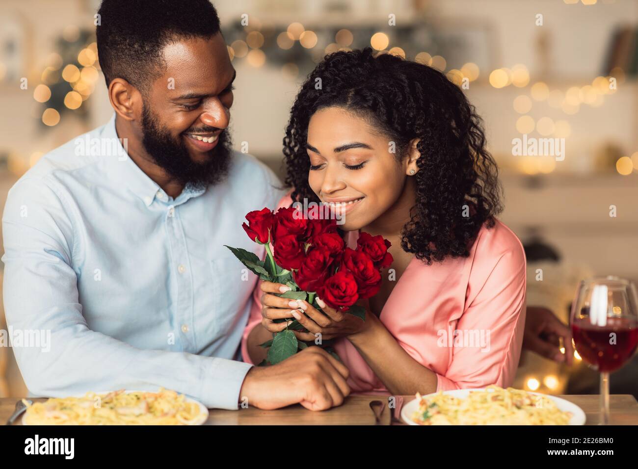 Young black man giving flowers to woman Stock Photo Alamy