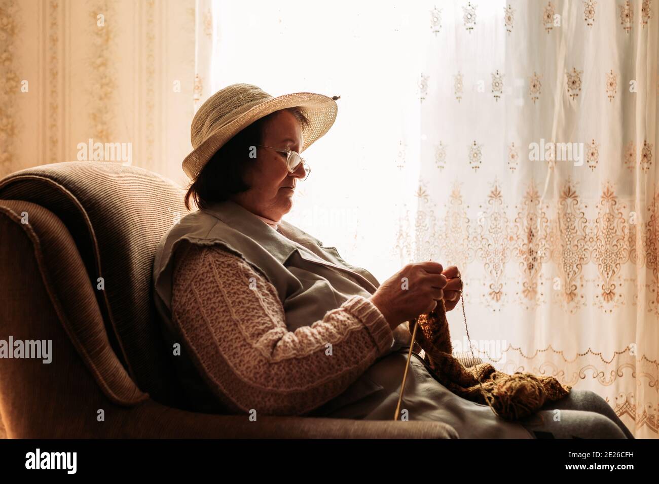 Elderly woman knitting sweater for her grandchildren Stock Photo - Alamy