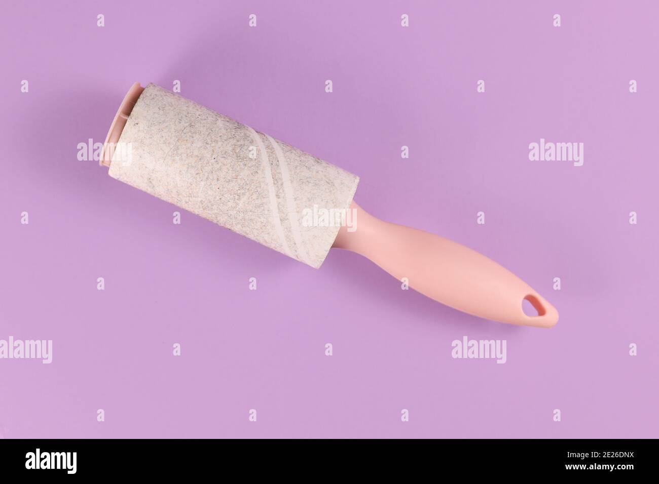 Used fluff roller for cleaning clothes on violet background Stock Photo