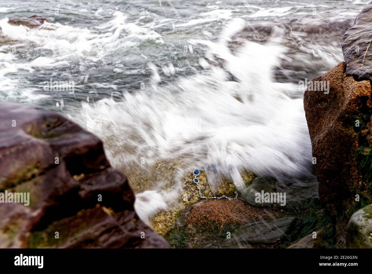 A storm washed away a jewellery to the sea coast rocks. Stock Photo