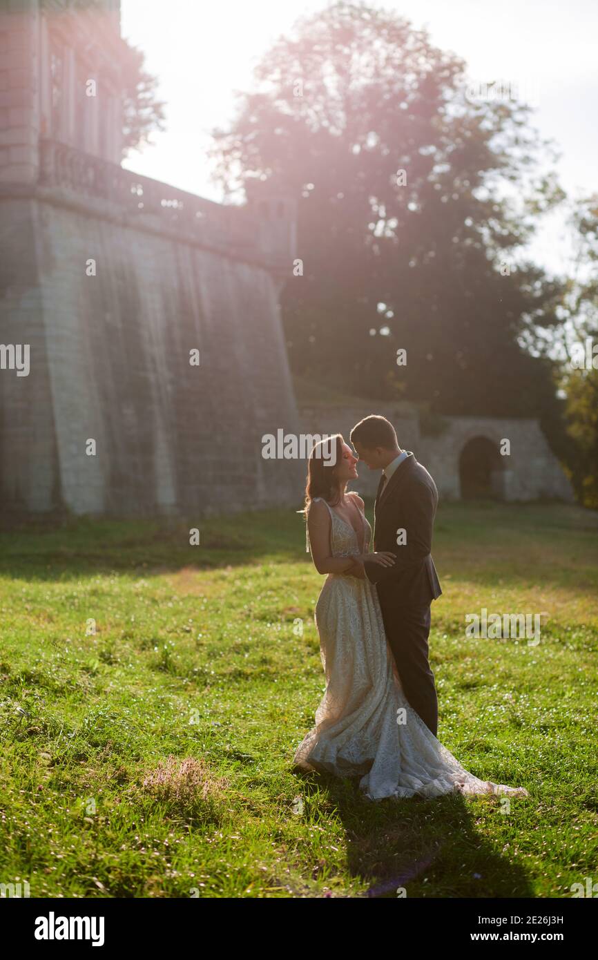 Beautiful bride and goom standing together in front of old palace. Wedding couple. Wedding photo Stock Photo