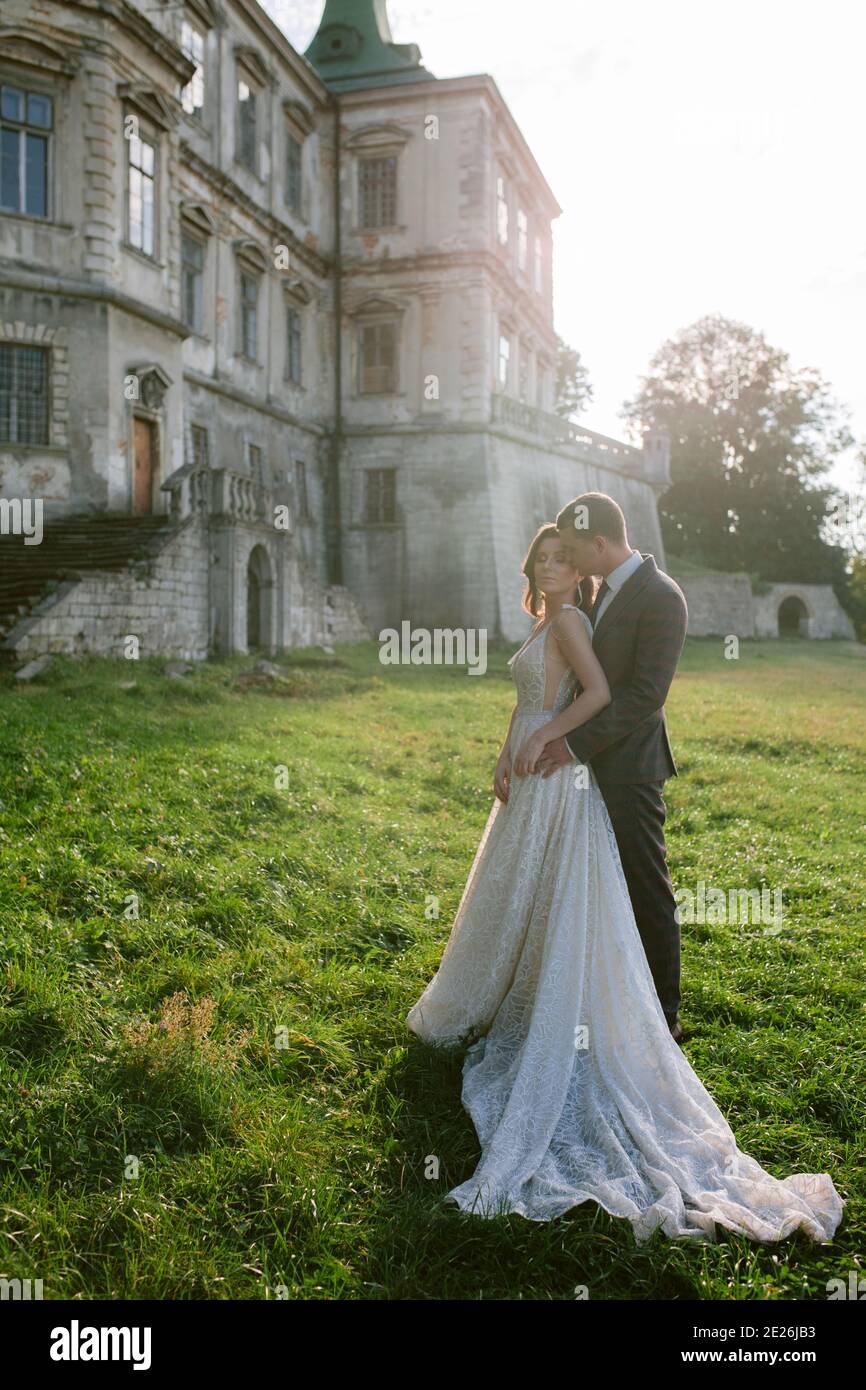 Beautiful bride and groom standing in front of old castle. Wedding ...
