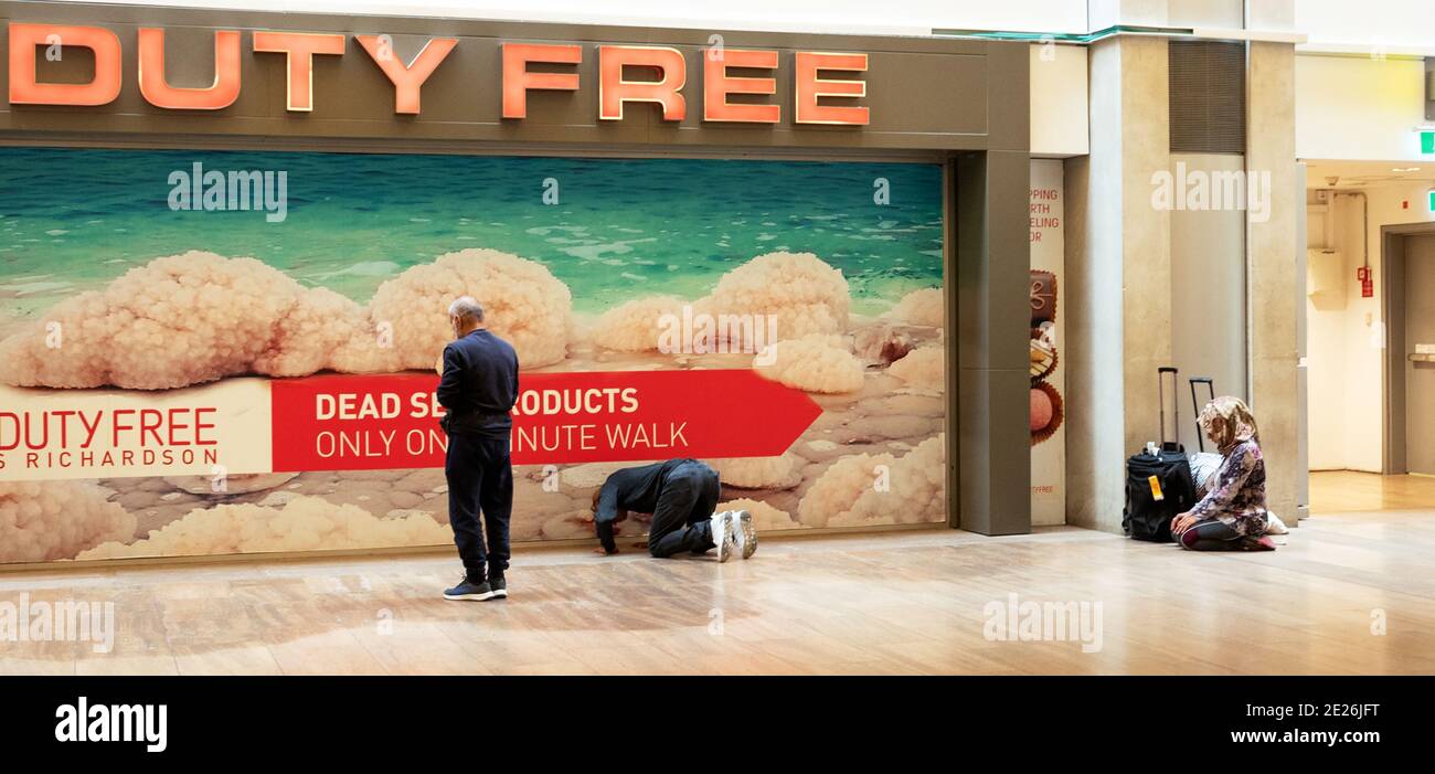 Muslim passengers pray while waiting for flights in departure hall area near Duty Free shops in