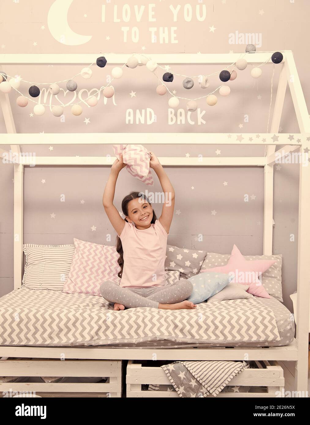 Home is best. Small girl feel happy at home. Little child sit on bed. Cozy home. Home clothing. Fashion and style. Rest and relaxation. Bedtime routine. Leisure and lounge. Stock Photo