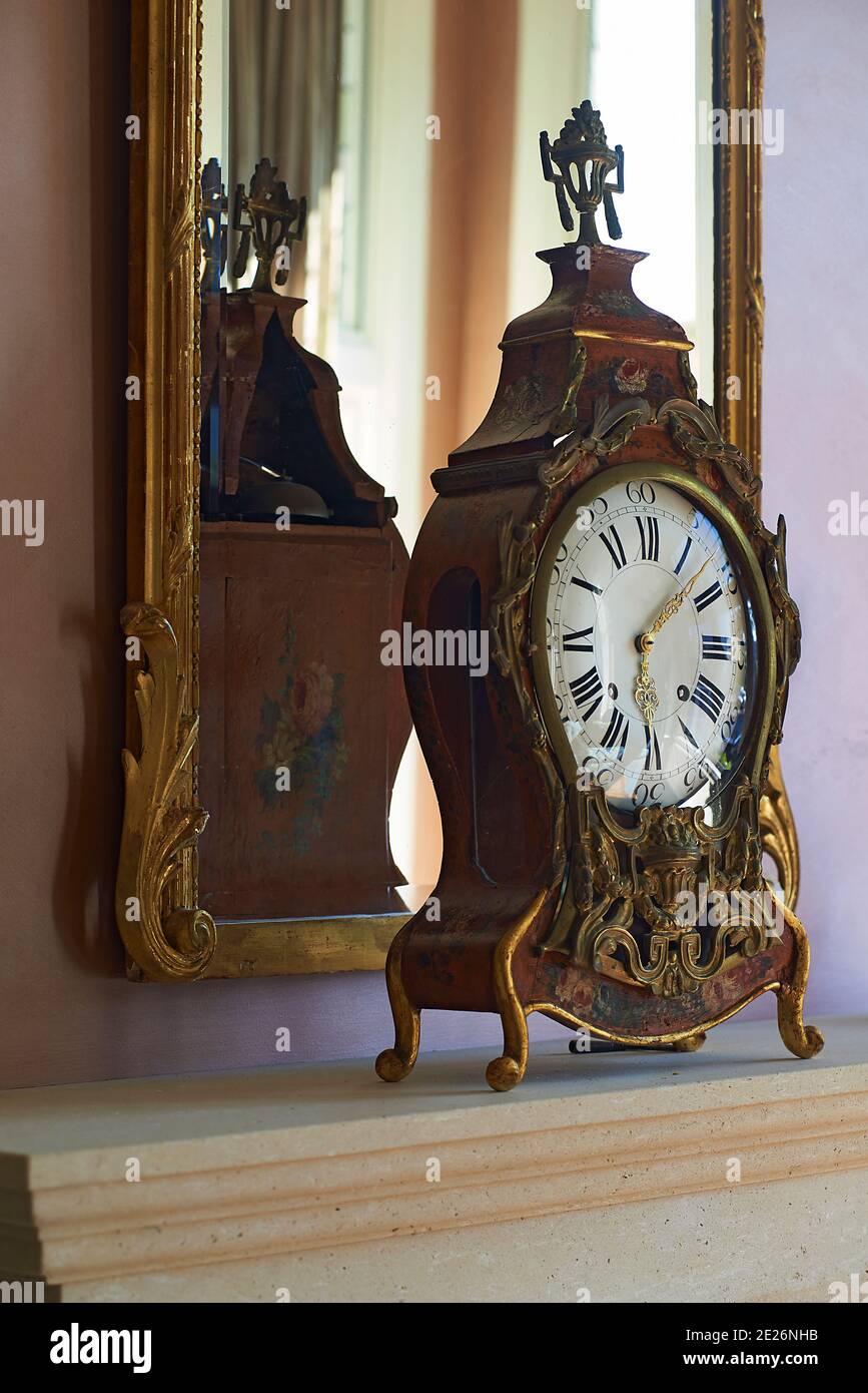 Antique standing clock in front of a mirror on display in living room