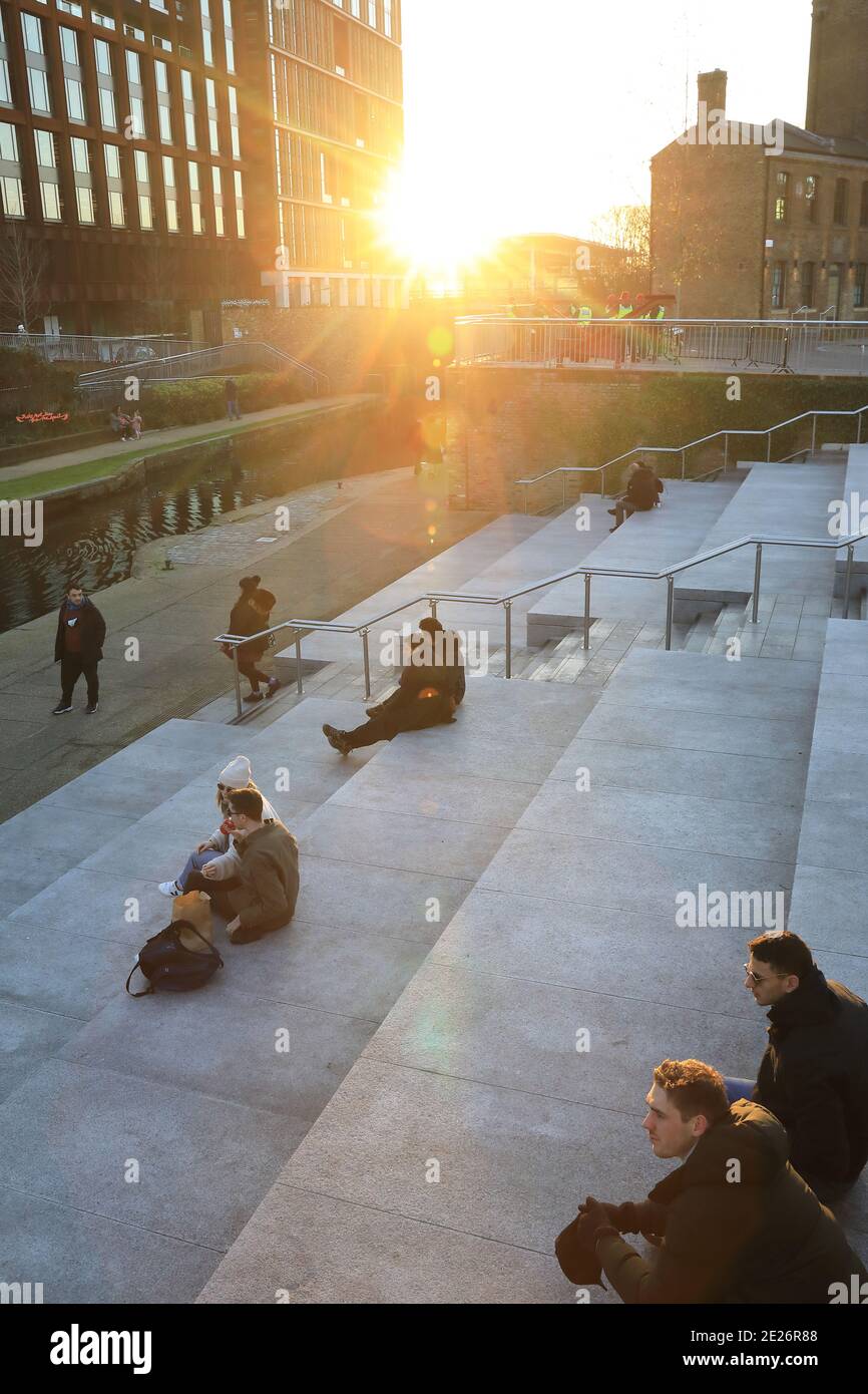 Social distancing in the Covid-19 pandemic in the winter sunshine on Granary Square at KIngs Cross, north London, UK Stock Photo