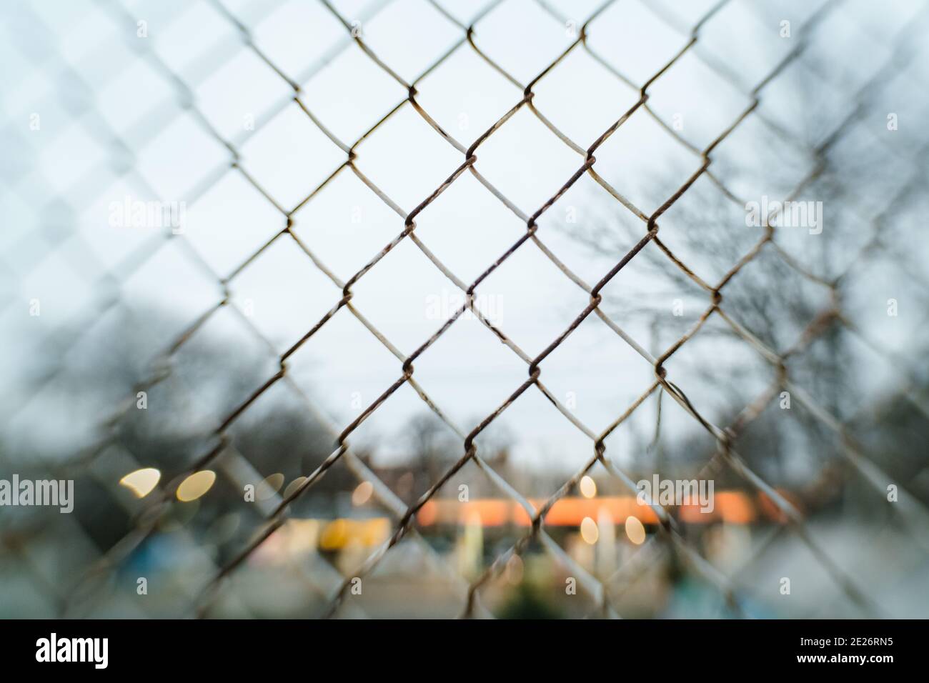 Chain link fence close up with street lights blurred Stock Photo - Alamy