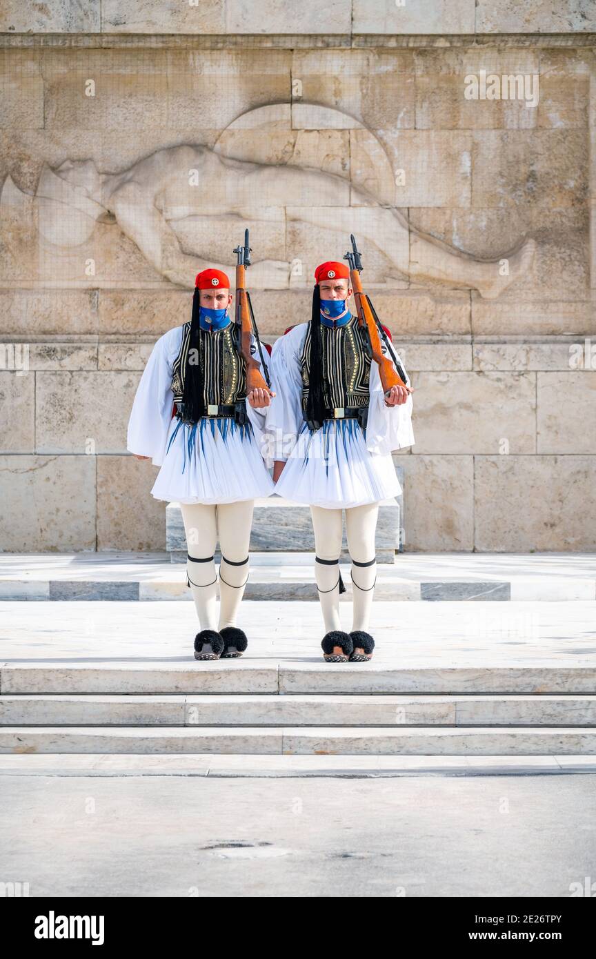 Soldiers of the Greek presidential guard (Evzone) with facemask in front of the tomb of the unknown soldier in Athens, Greece Stock Photo
