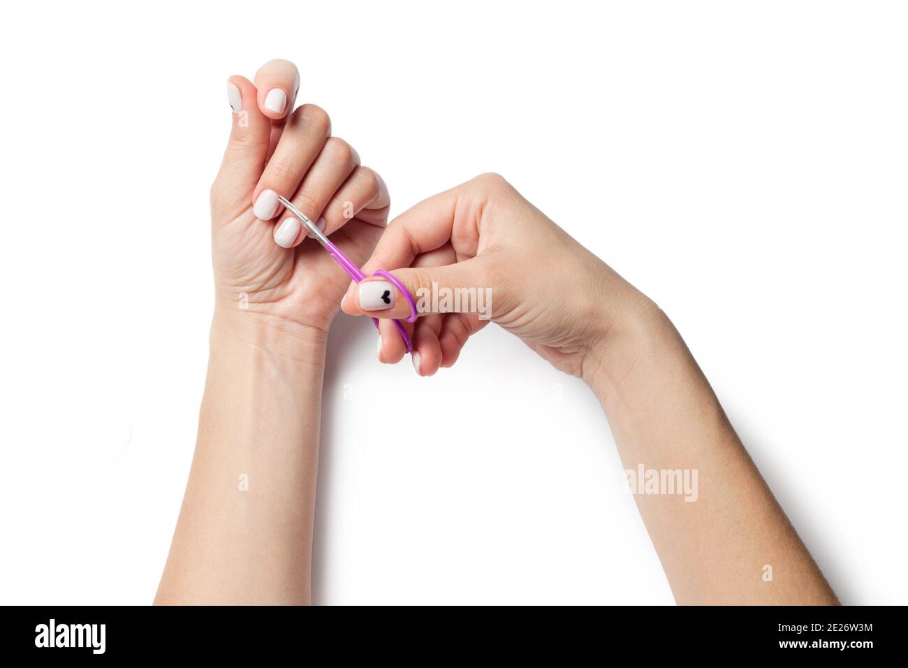 Female hands hold nail scissors. The girl does a manicure. isolated on white background. Stock Photo