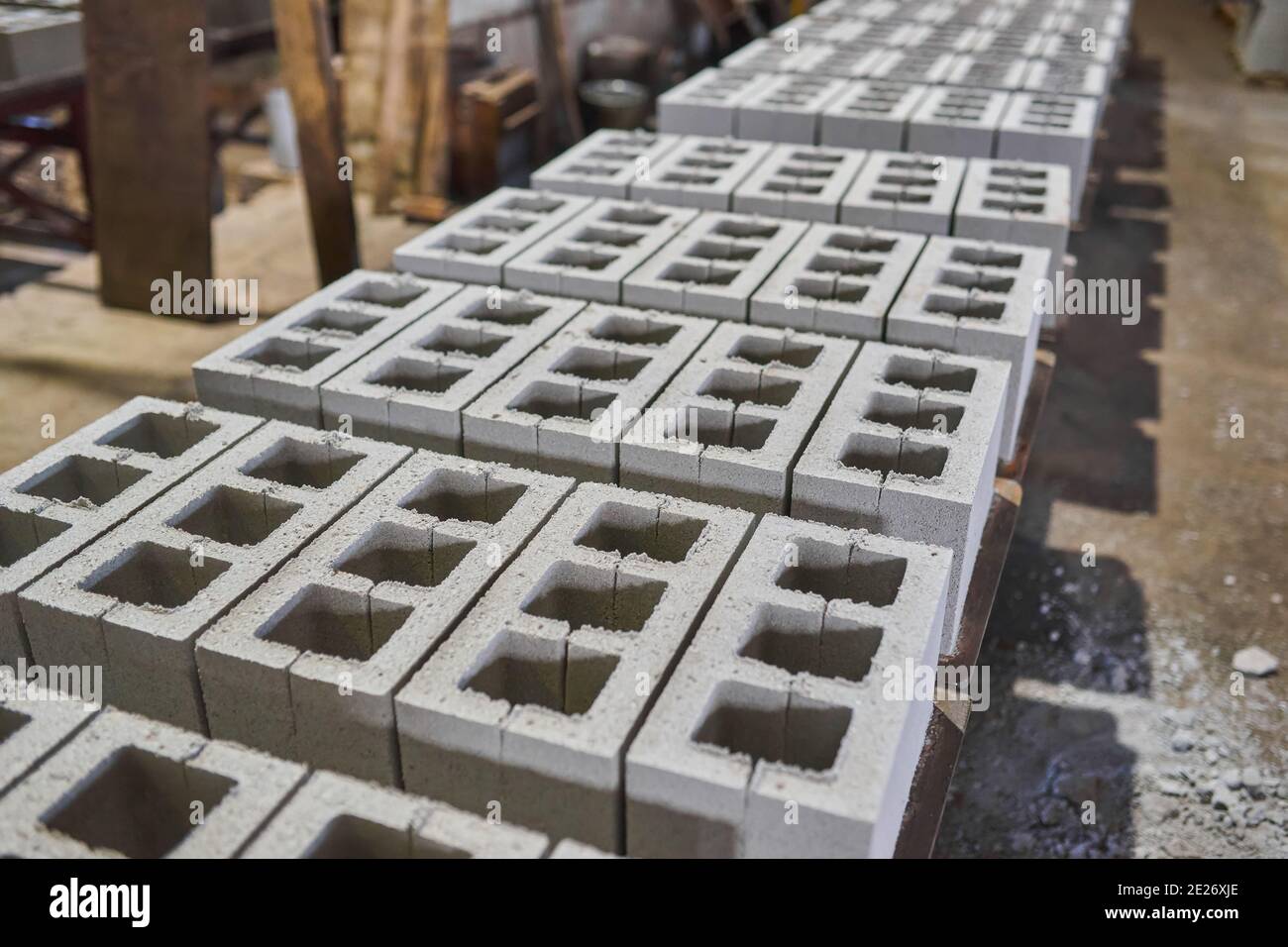 Industrial production of building materials from pressed cement mortar. High quality concrete block or brick. Finished products stacked Stock Photo - Alamy