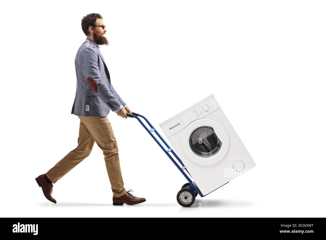 Full length profile shot of a man transporting a washing machine with a