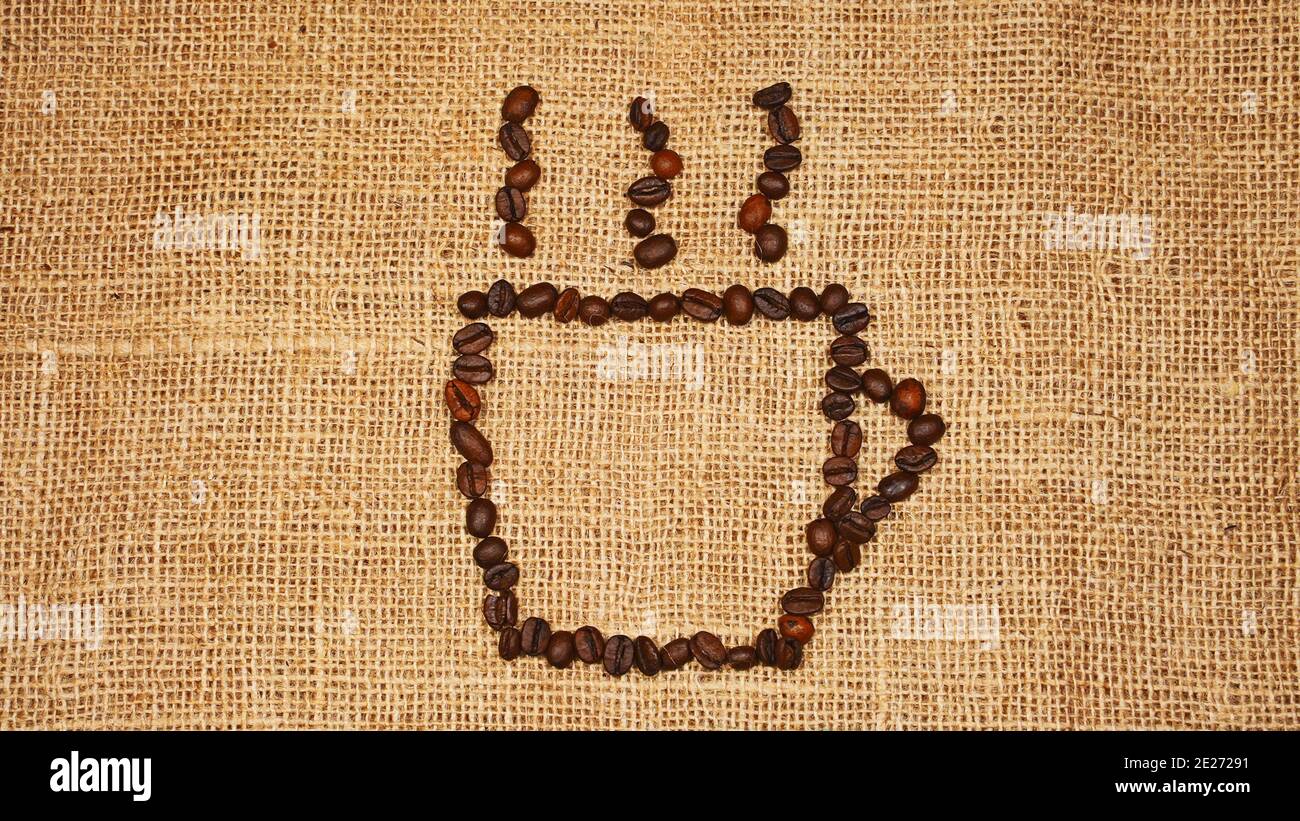 Roasted coffee beans arranged in the form of coffee cup logo. Stock Photo