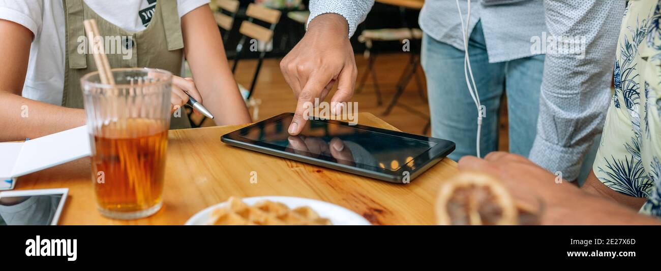 Unrecognizable friends using tablet in a coffee shop Stock Photo