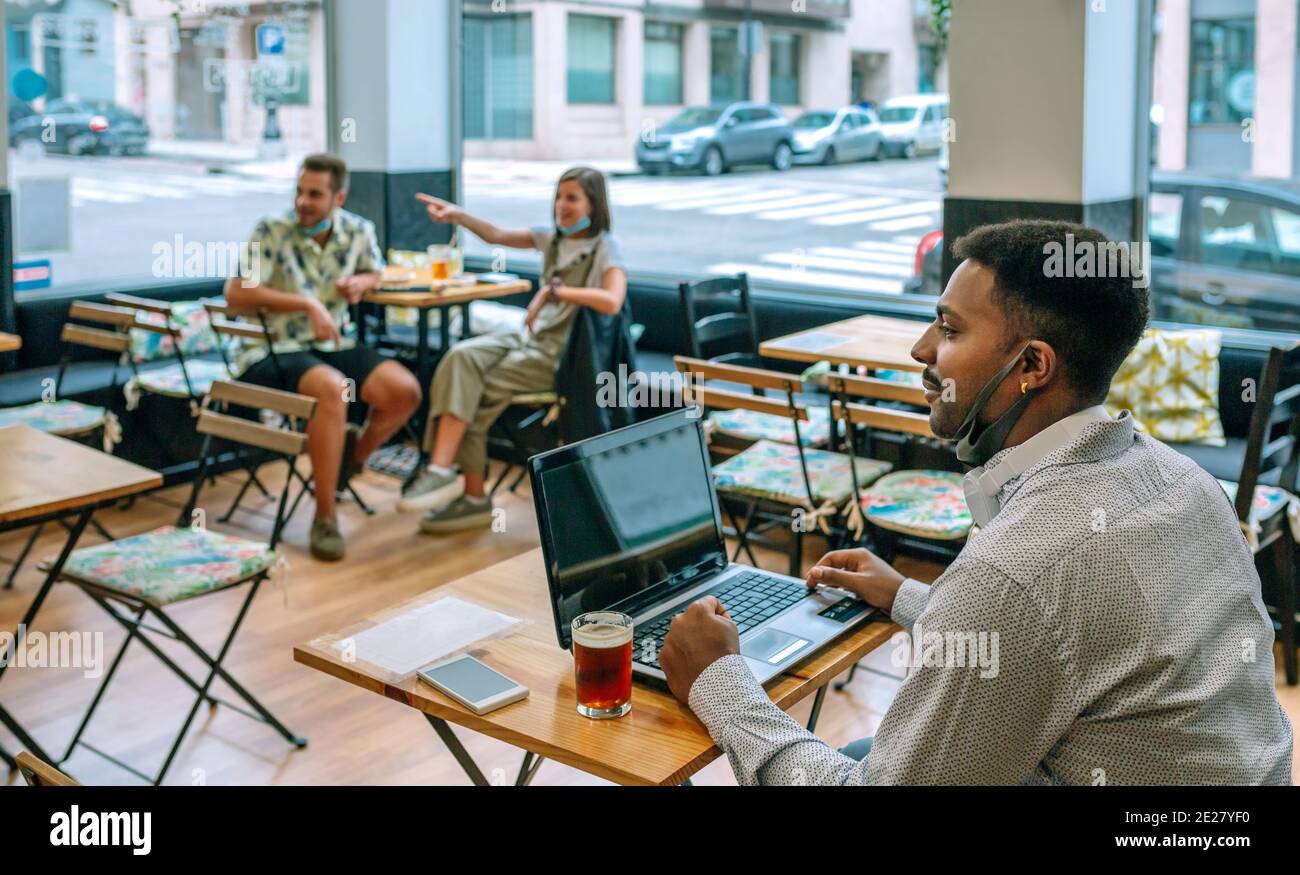 Man teleworking with laptop in coffee shop Stock Photo