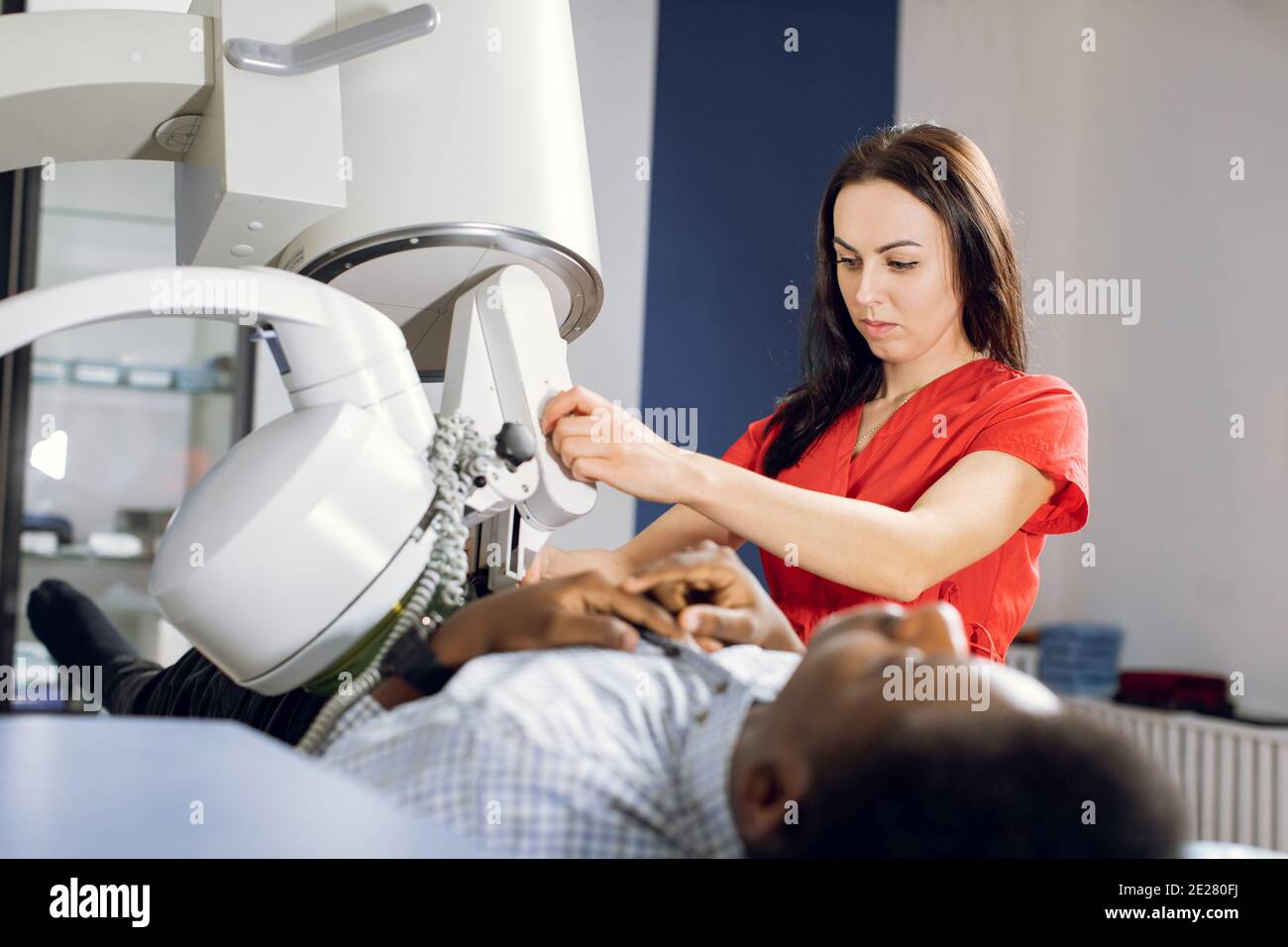 Procedure of extracorporeal shock wave lithotripsy in modern urology medical center. Close up of pretty Caucasian woman doctor providing stone Stock Photo