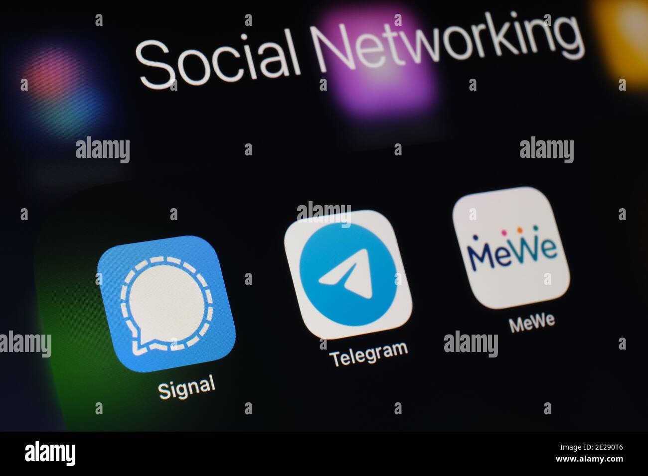Stafford, UK - January 12 2021: Signal, Telegram, MeWe apps and blurred finger above them. Social network apps gaining popularity in the United States Stock Photo