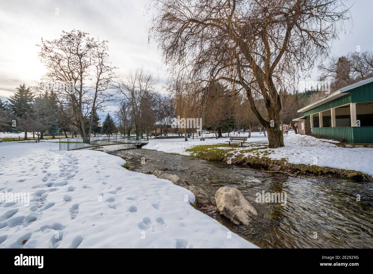 A small creek runs through the small public park with snow during winter at Rathdrum, Idaho USA. Stock Photo