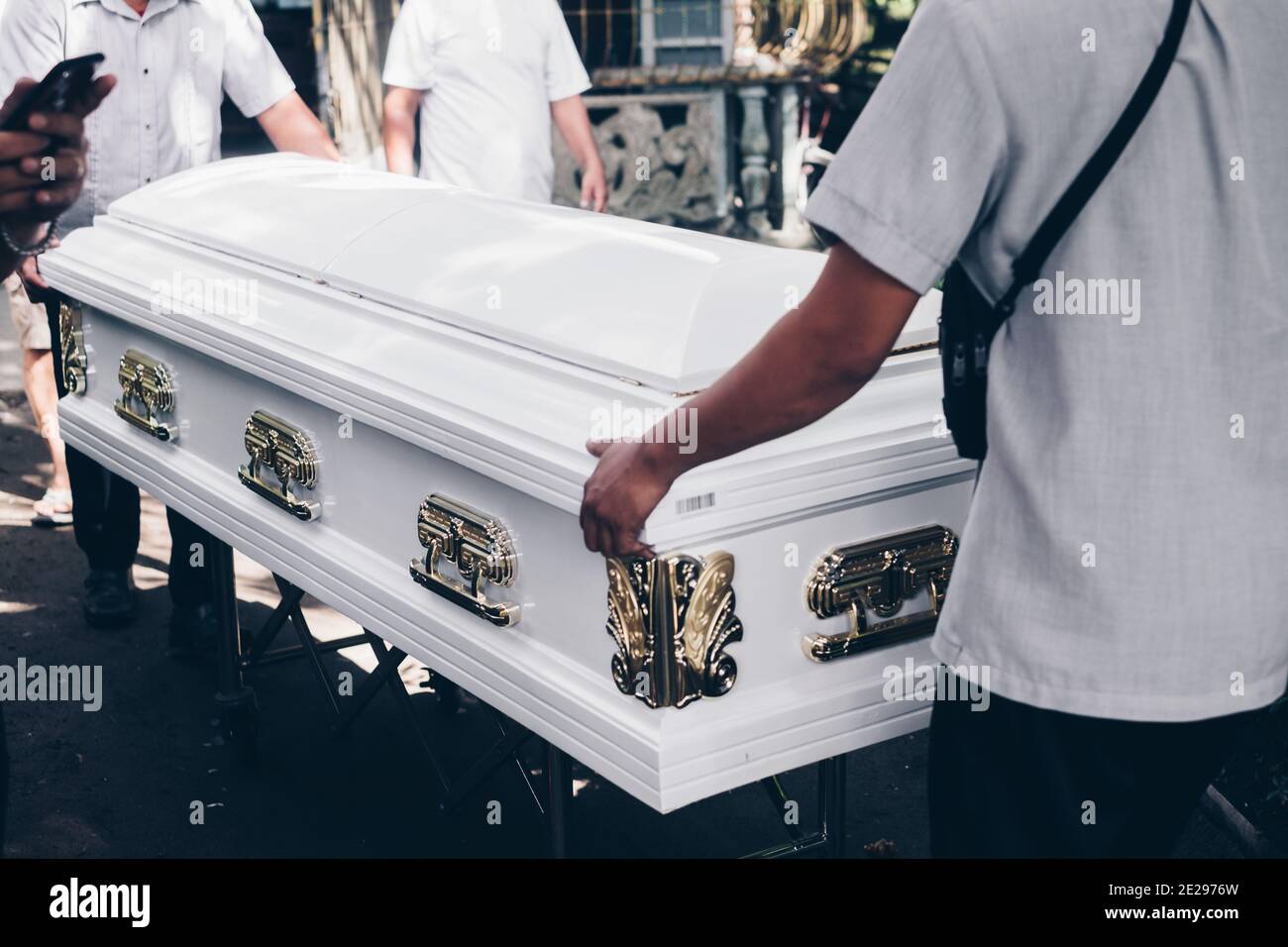 Pallbearers guiding the casket out during funeral procession. Selective focus. Stock Photo