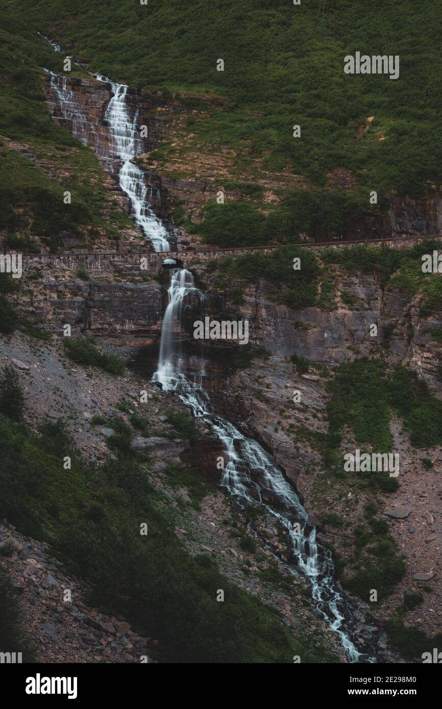Aster Falls Tumbles Over Cliff and Under Going to the Sun Road in Glacier National Park Stock Photo