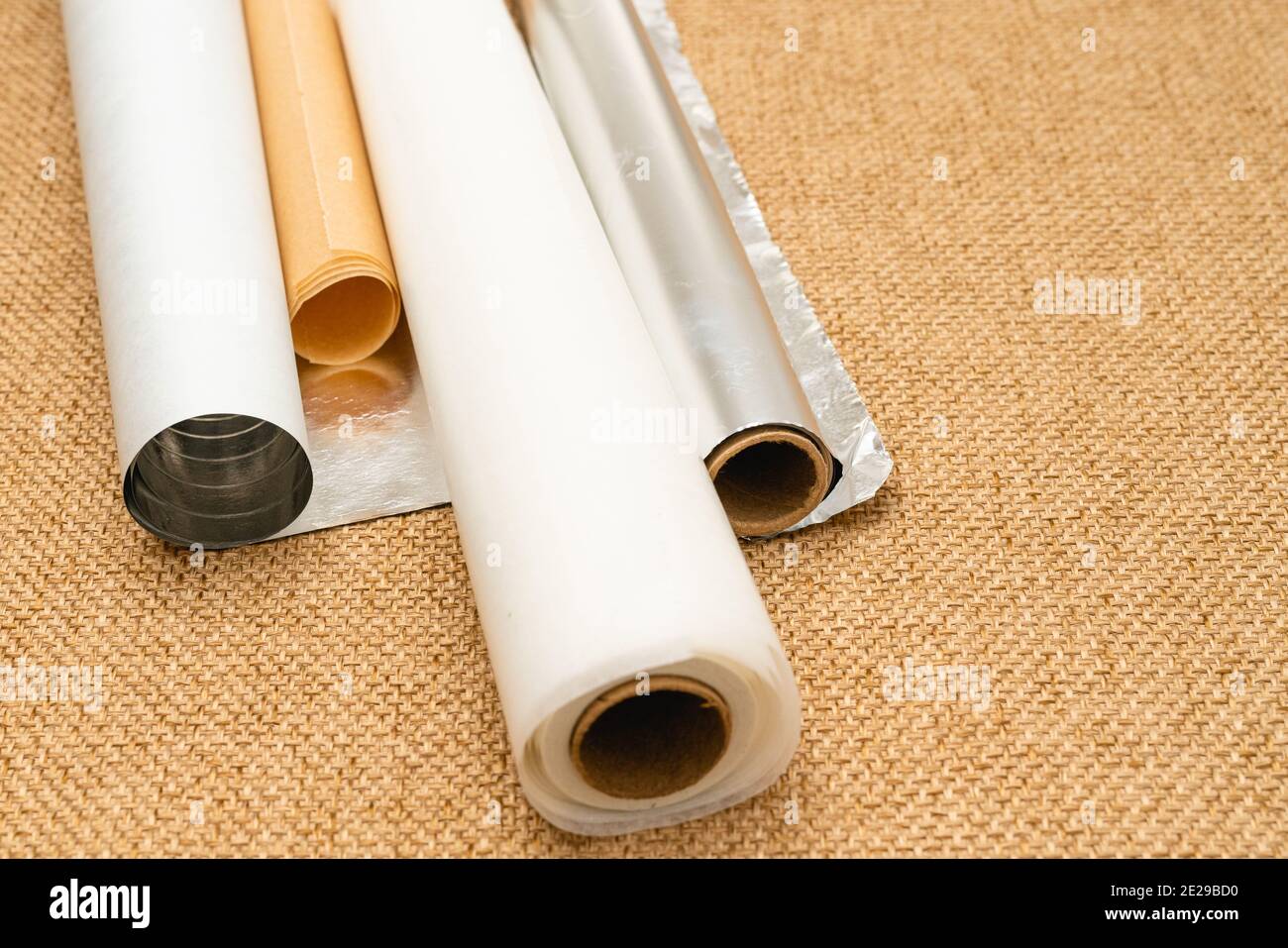 https://c8.alamy.com/comp/2E29BD0/different-type-of-paper-for-baking-needs-parchment-paper-foil-wax-paper-close-up-on-rustic-background-2E29BD0.jpg