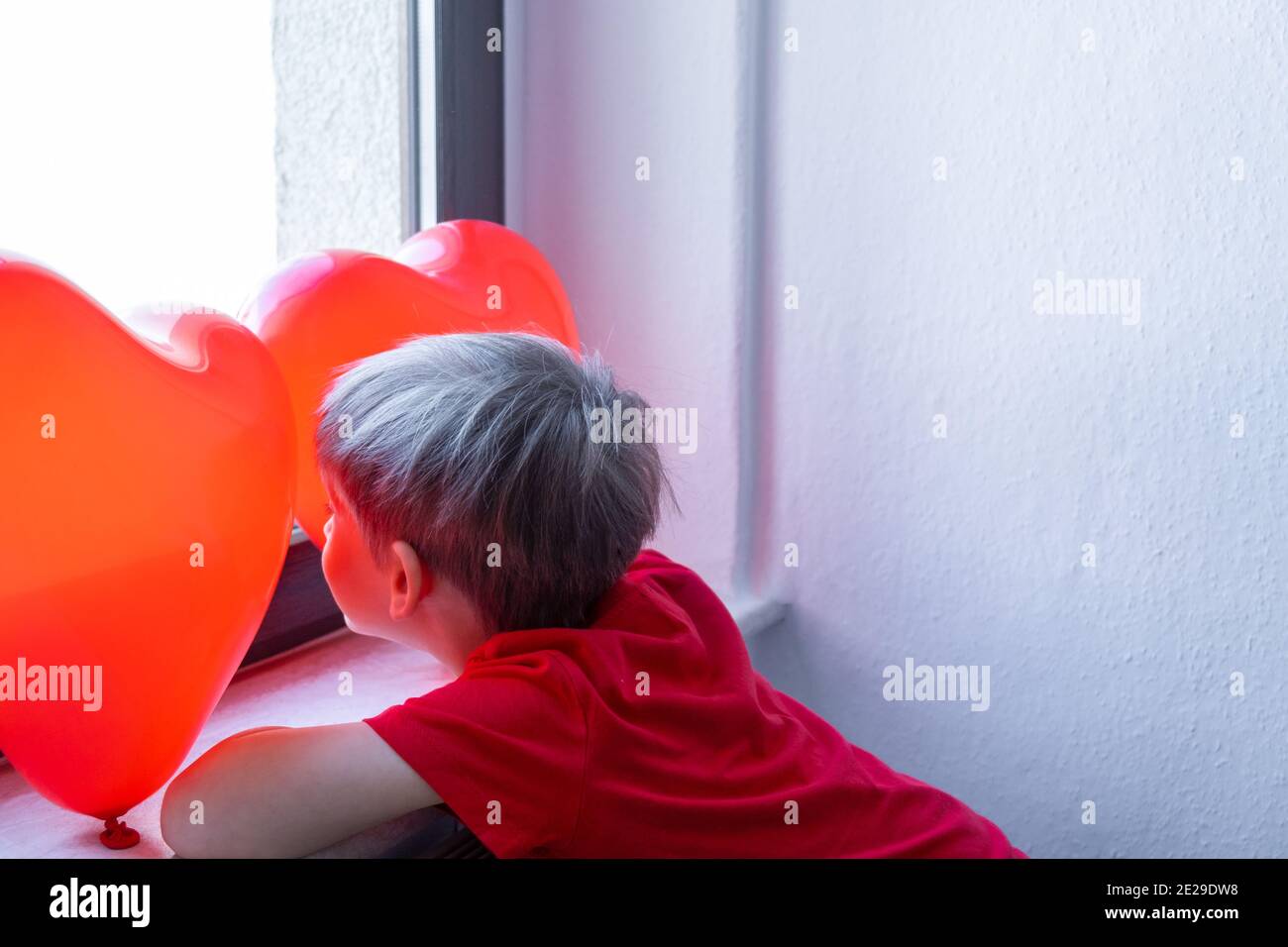 little boy with blond hair with red balloons, valentine's day Stock Photo