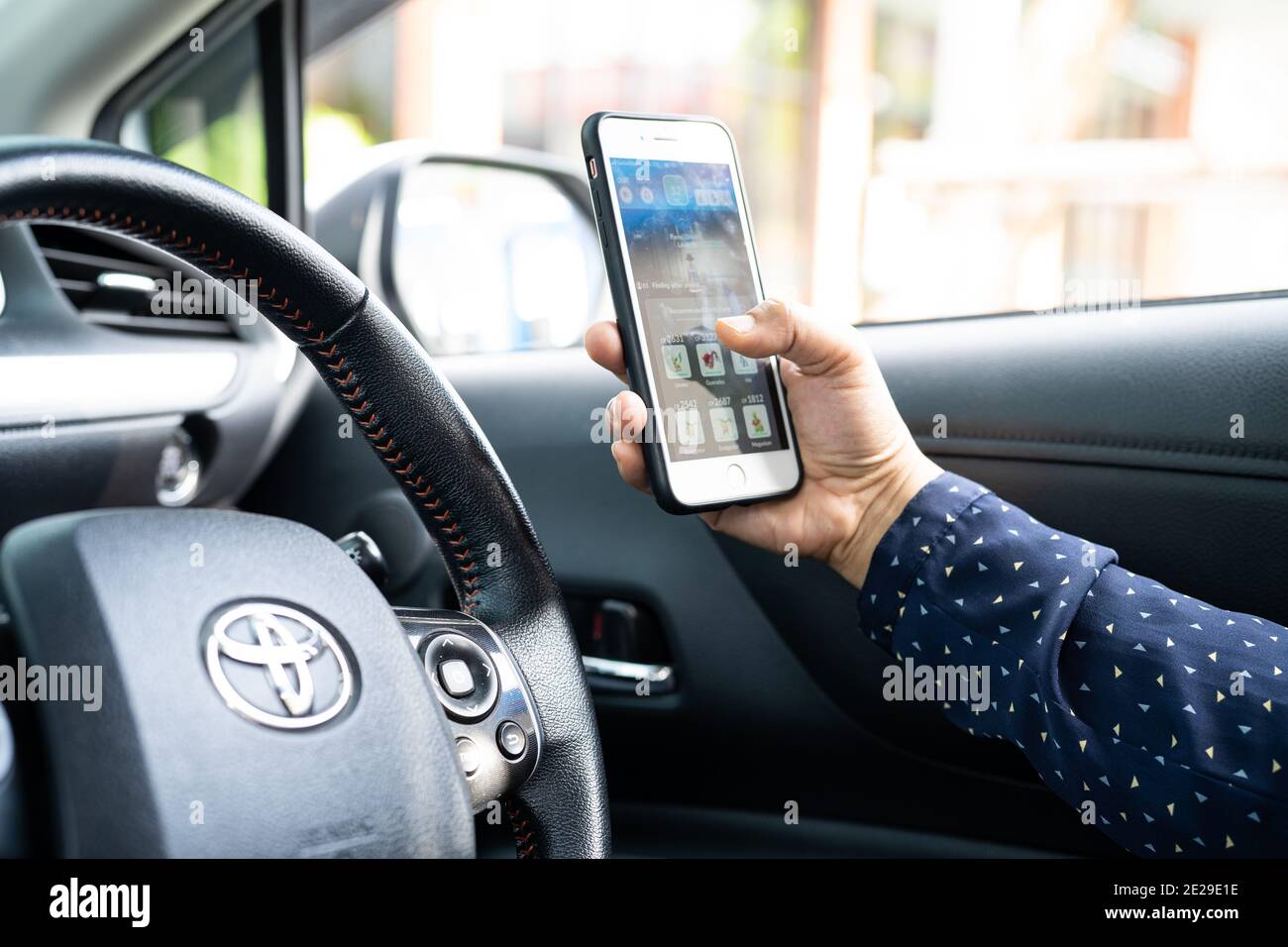 Bangkok, Thailand, July 1, 2020 Holding iPhone in toyota sienta car to communication with family and friends. Stock Photo