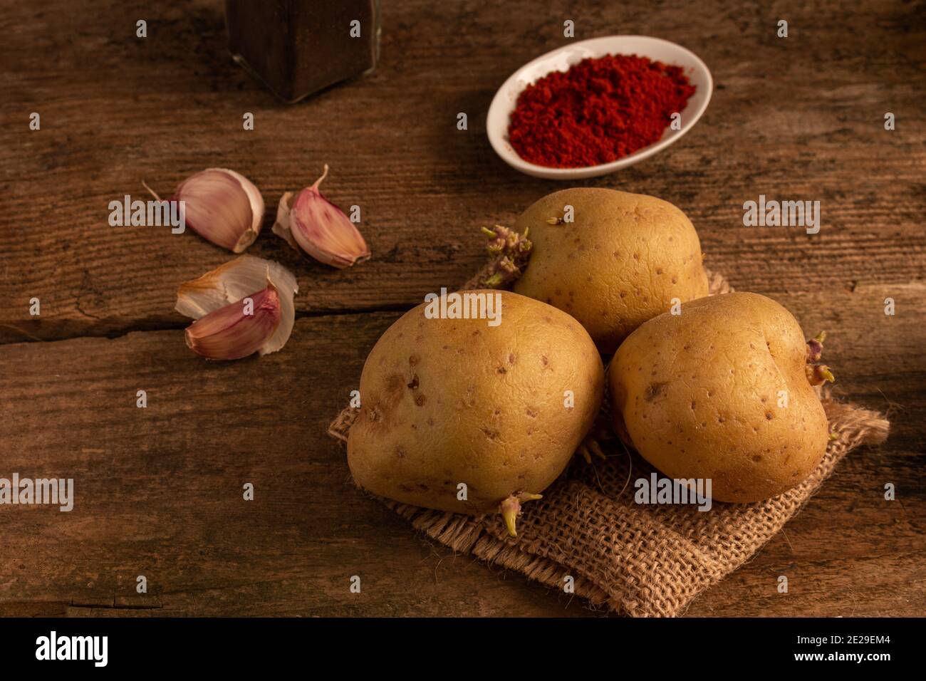 Shot of potatoes, garlic and peppe on a wooden table Stock Photo