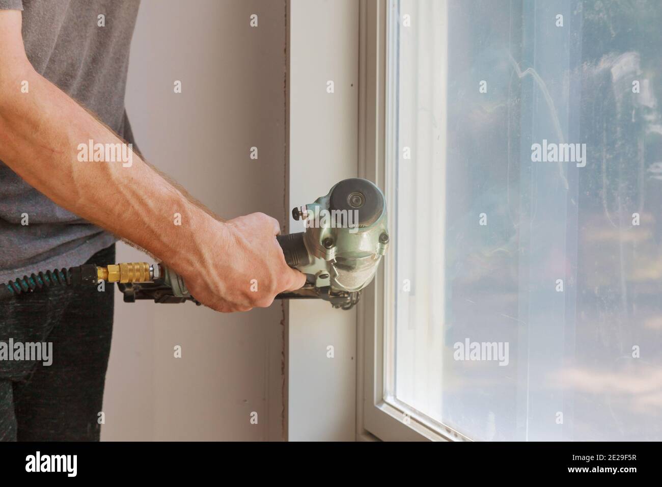 Worker installing trim around a window molding installed moldings